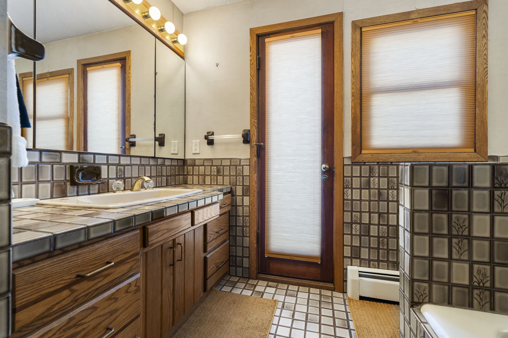 You'll love the unique tiled surfaces and natural light in this charming main floor bathroom.