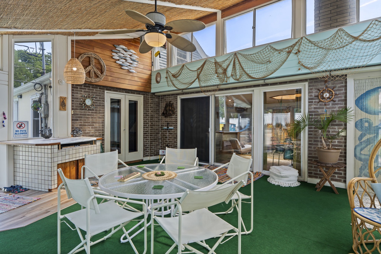 Relax in your nautical-themed sunroom with vintage charm, perfect for morning coffee or evening gatherings under tropical ceiling fans.