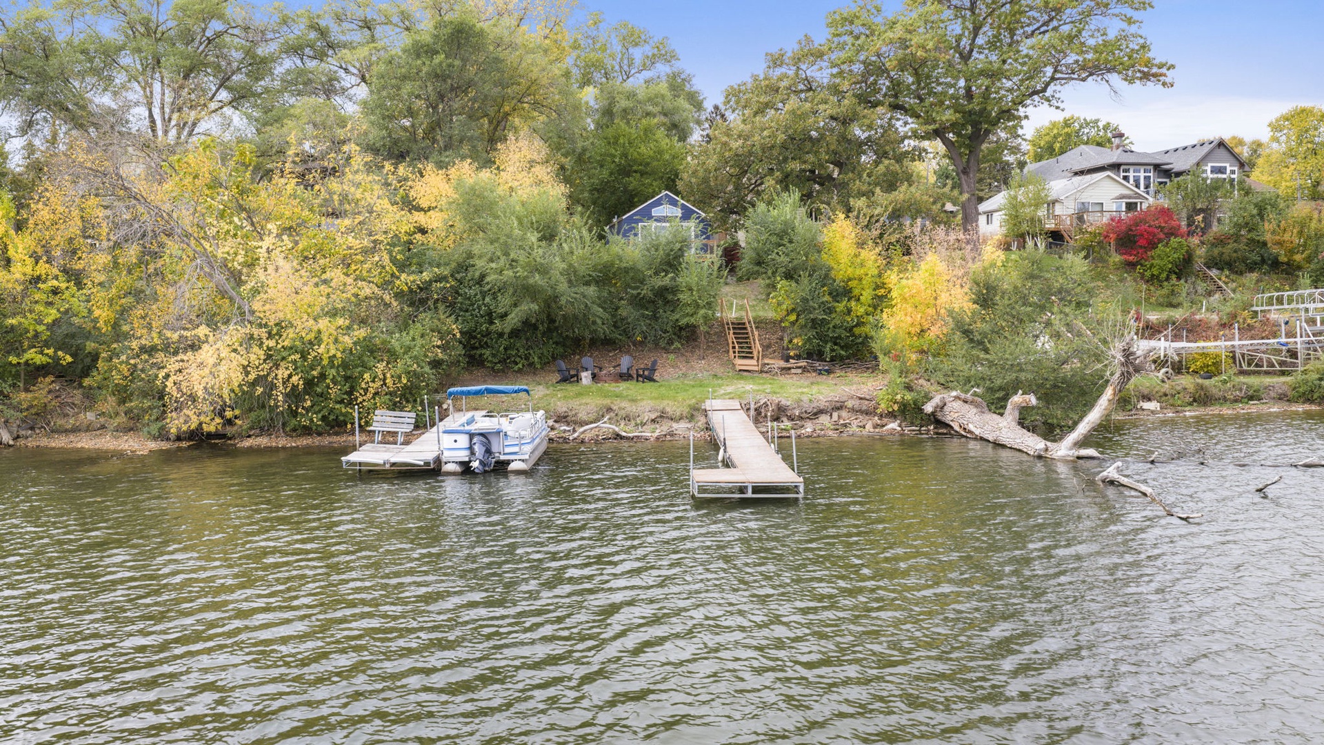 Waterfront property with private dock on a serene lake, surrounded by lush trees and natural beauty.