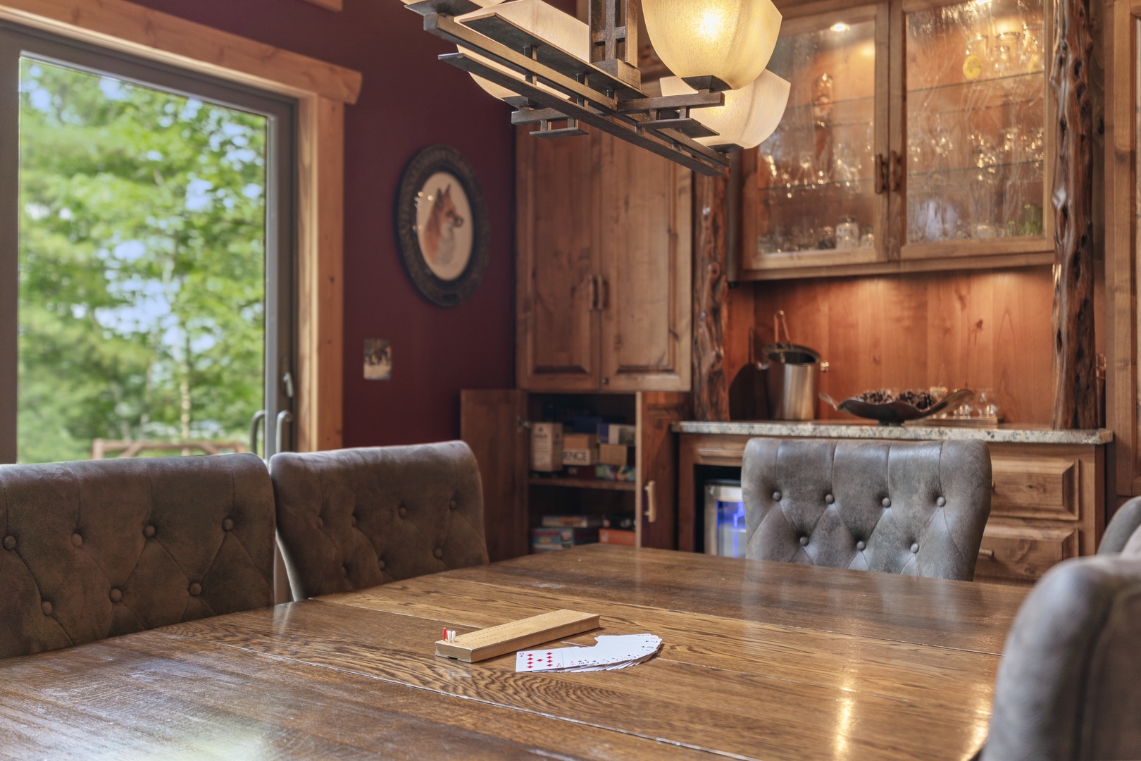 Gather around this rustic dining table for family game nights, with warm wood tones and nature views creating your cozy mountain retreat.