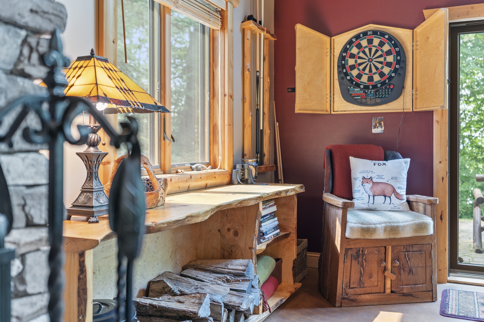 Challenge yourself to a game of darts or unwind with a book in this charming nook where natural light pours through the windows and rustic details invite relaxation.