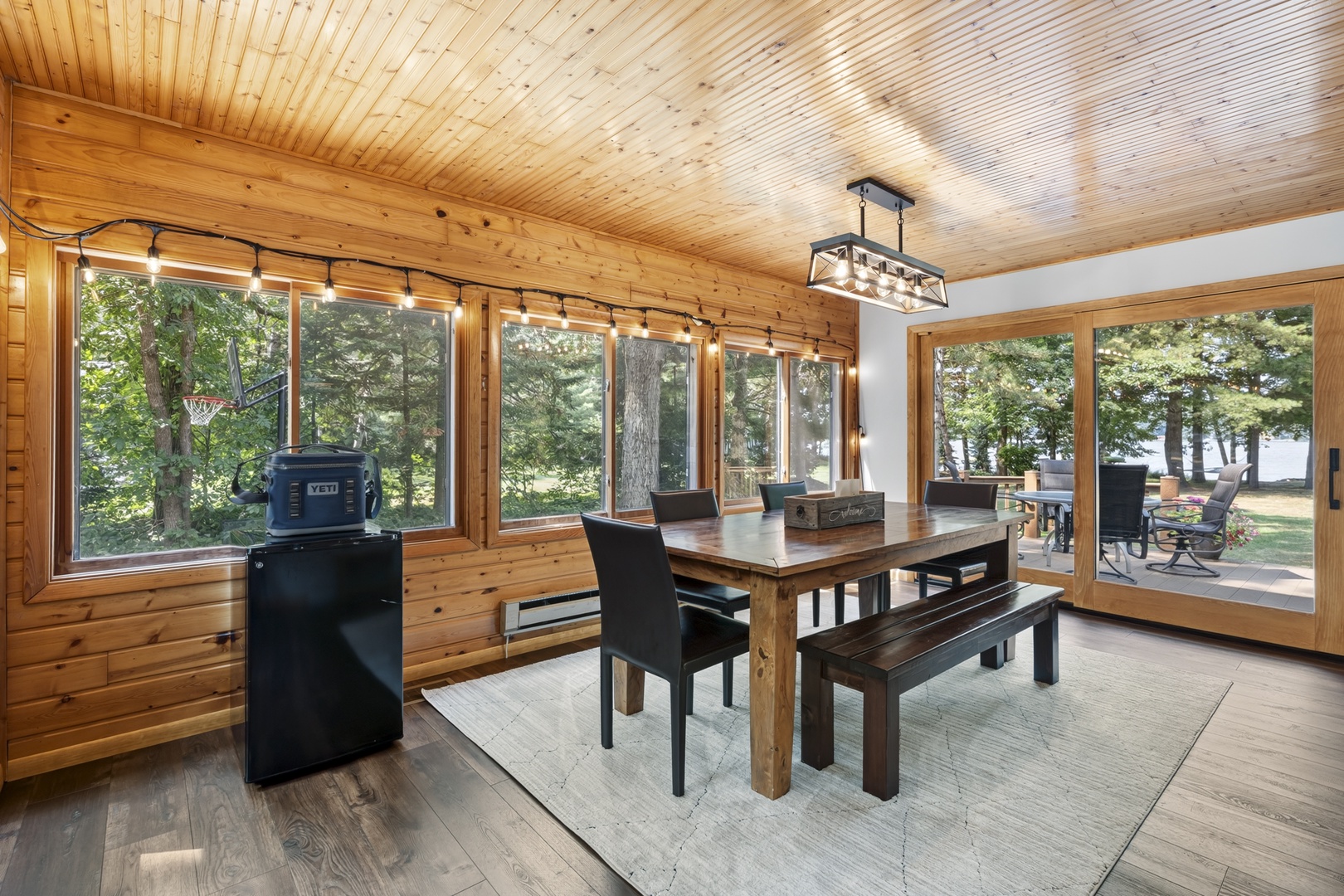 Gather around your rustic dining table with sweeping views of the lake framed by towering trees—perfect for long breakfasts and evenings that stretch into night.