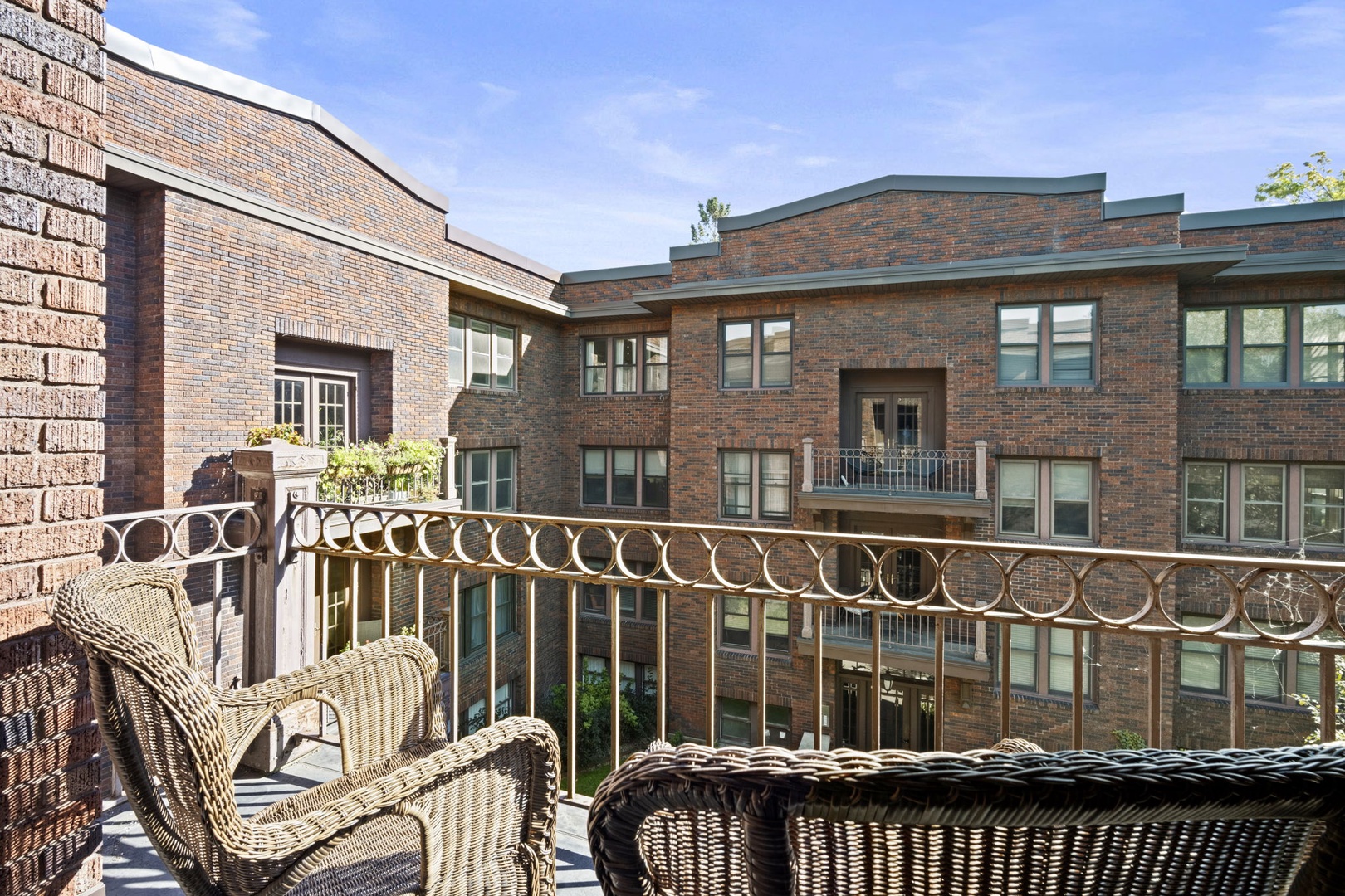 A daylight photo showing the brick facade of this multi-story property and the surrounding residential neighborhood beyond.