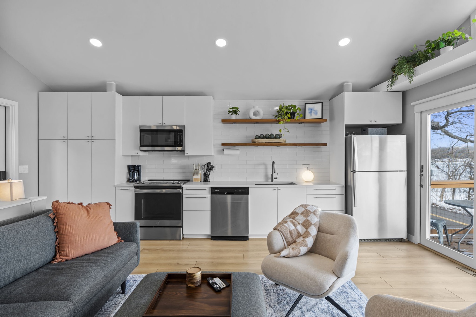 Your bright open-plan living space seamlessly blends kitchen and lounge, with modern appliances and cozy seating perfect for relaxing together.
