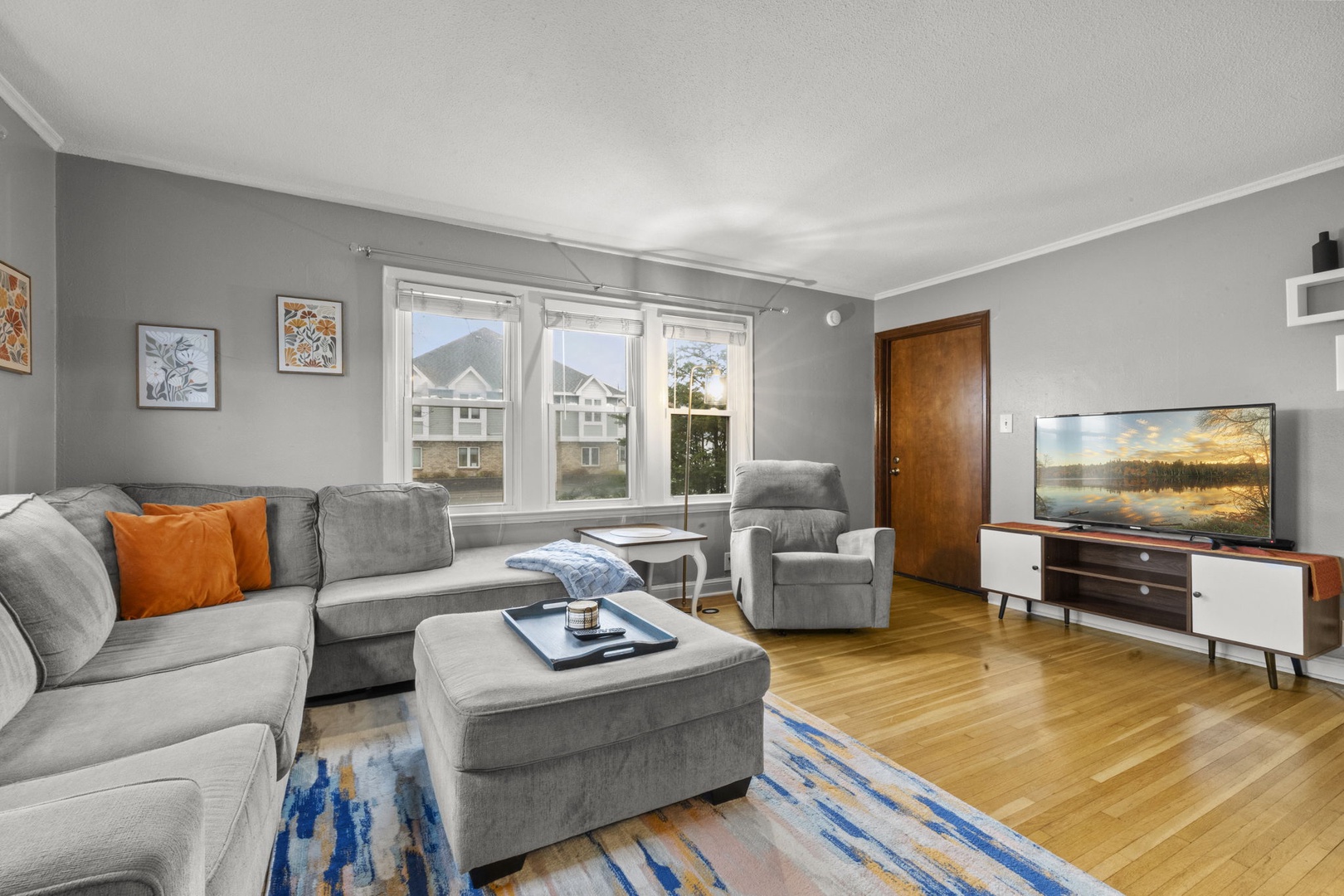 Sink into the plush gray sectional and unwind in your bright, inviting living space. Warm wood floors and thoughtful decor create a cozy retreat where you can relax after exploring.