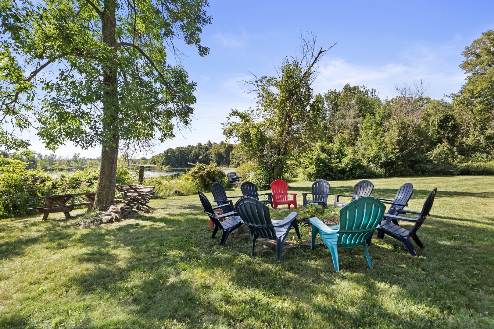Gather around the firepit in colorful Adirondack chairs, where stories and laughter blend with the peaceful lakeside setting and open sky.