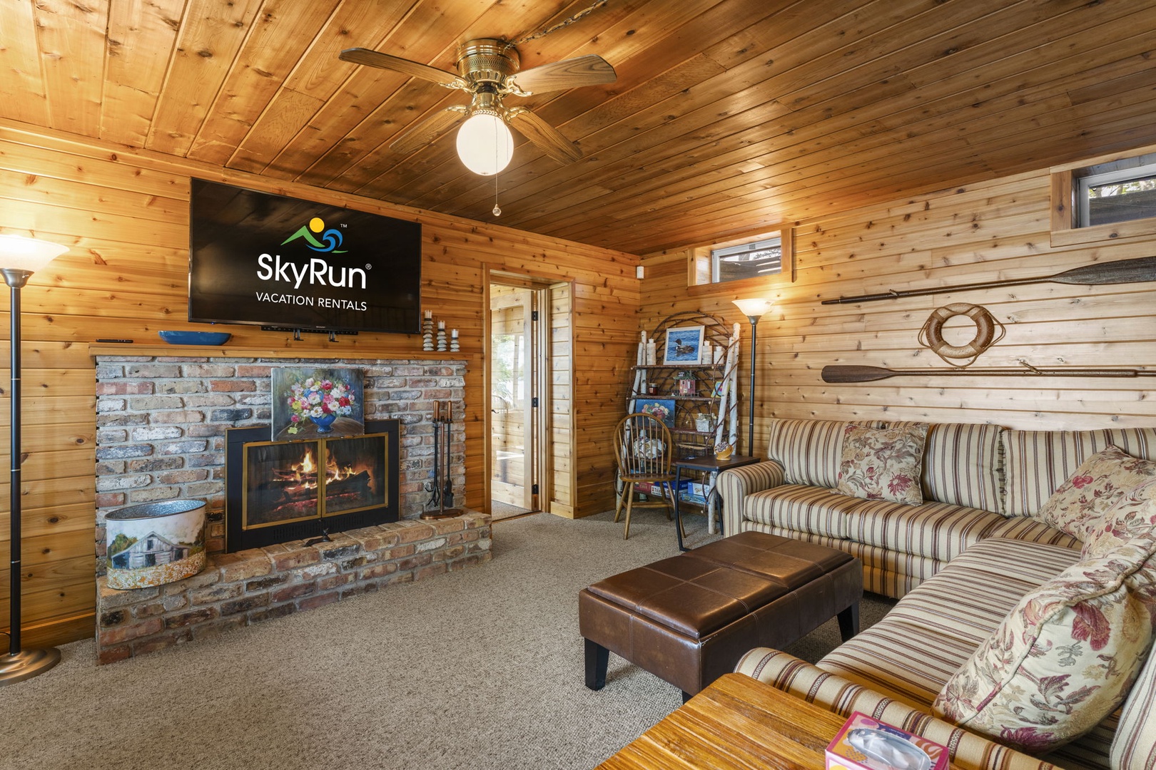 Curl up in this cozy living room where warm wood paneling and a crackling fireplace create your perfect mountain retreat. Unwind on comfortable seating and enjoy movie nights with the flat-screen TV.