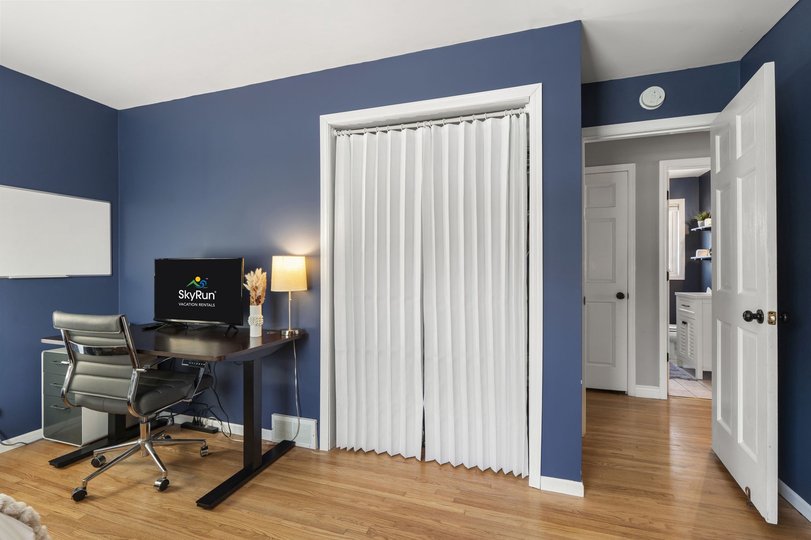 Office Bedroom Showing Desk Setup Closet with Curtain and Hallway to Bathroom
