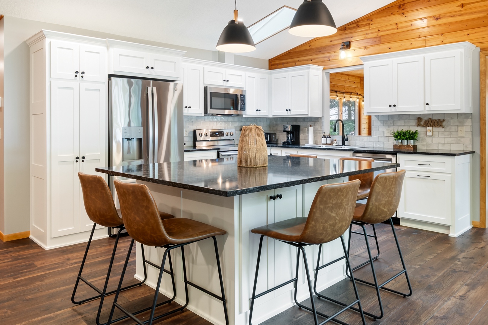 Gather around your spacious kitchen island with granite countertops and modern appliances. Bright white cabinetry and warm wood accents create a welcoming space for cooking and conversation.