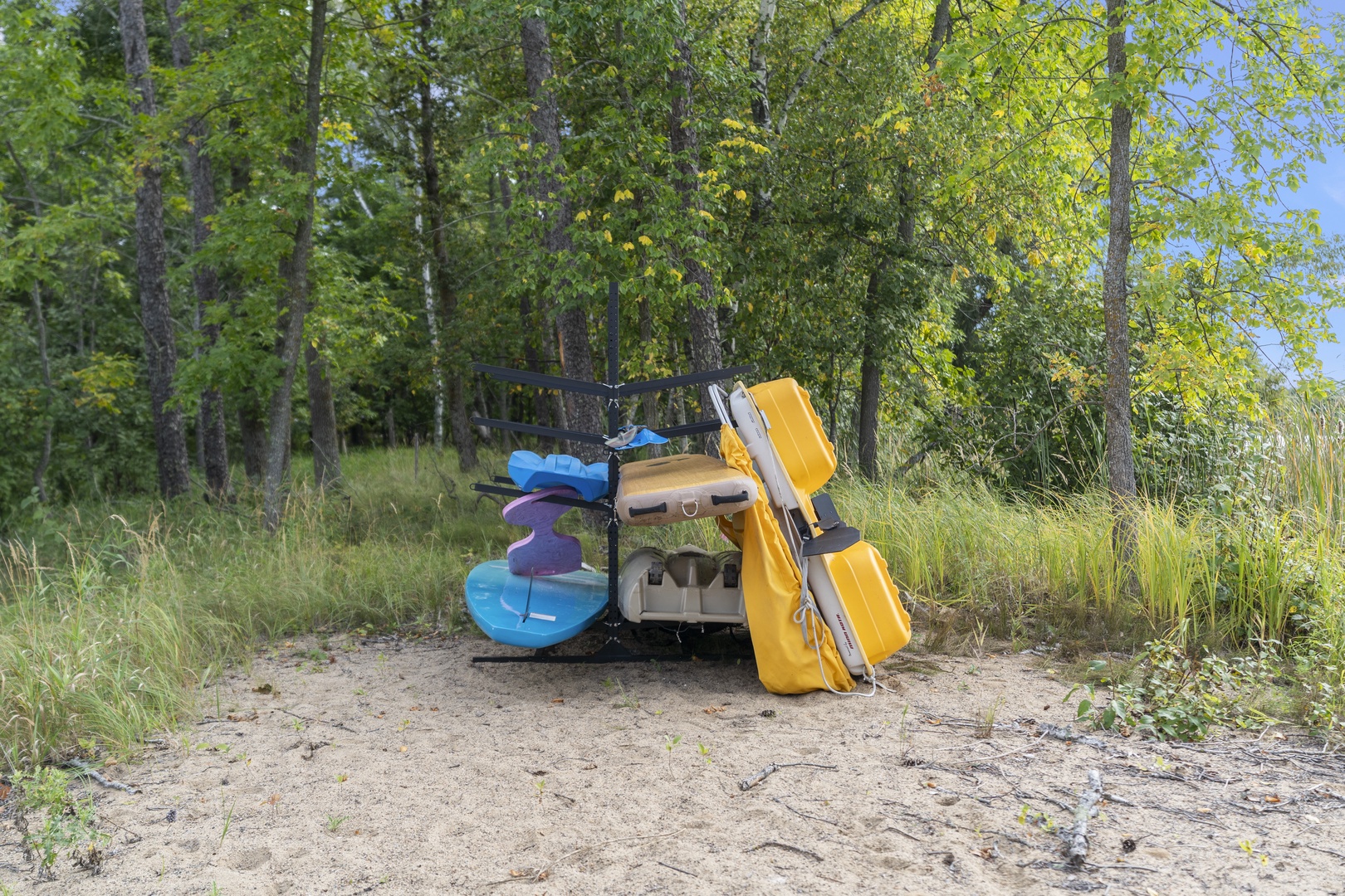 Kayaks and outdoor gear ready for waterfront adventures in the natural wooded surroundings of the property.