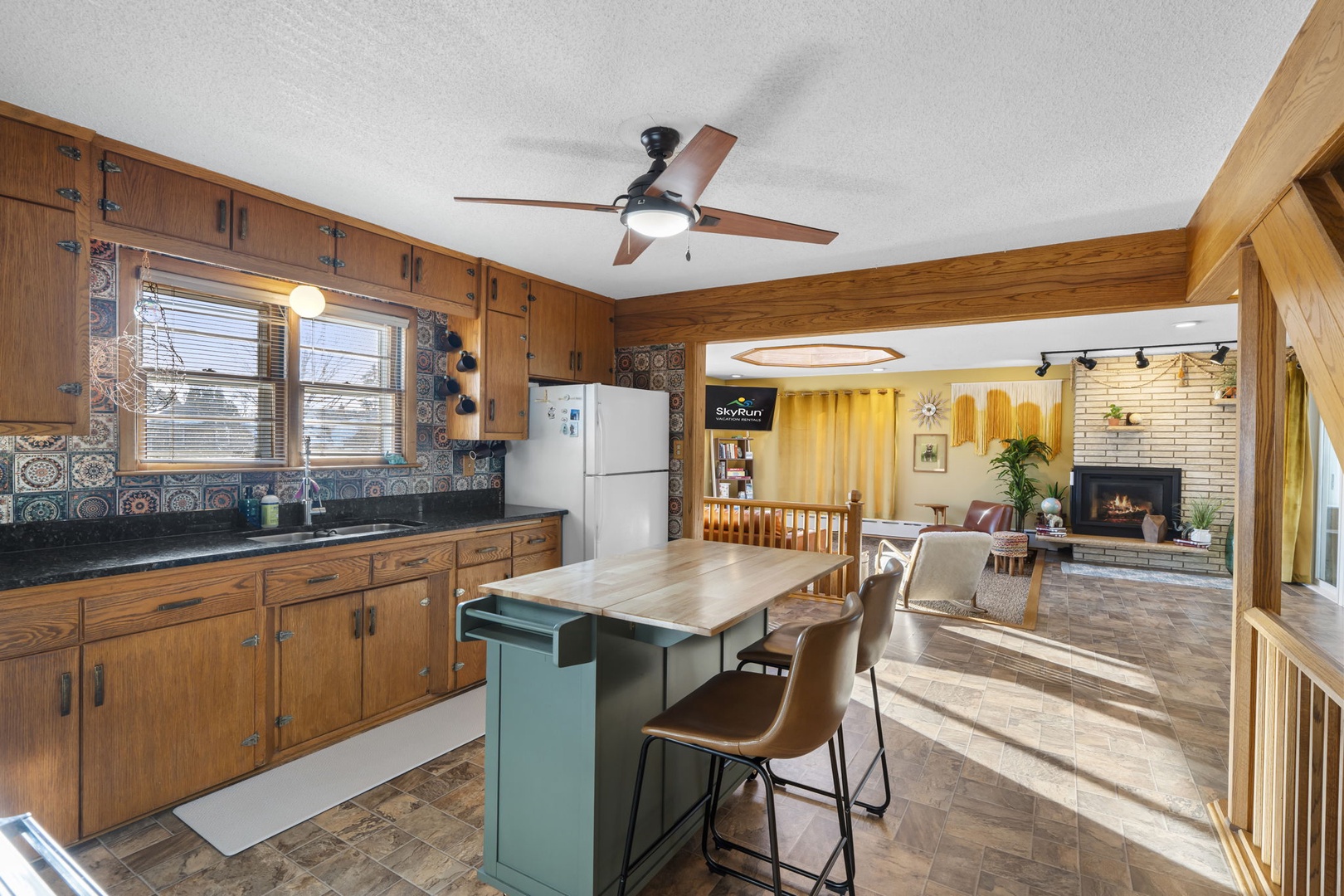 Gather around your spacious kitchen island for morning coffee while natural light streams through windows, connecting seamlessly to your cozy living area.