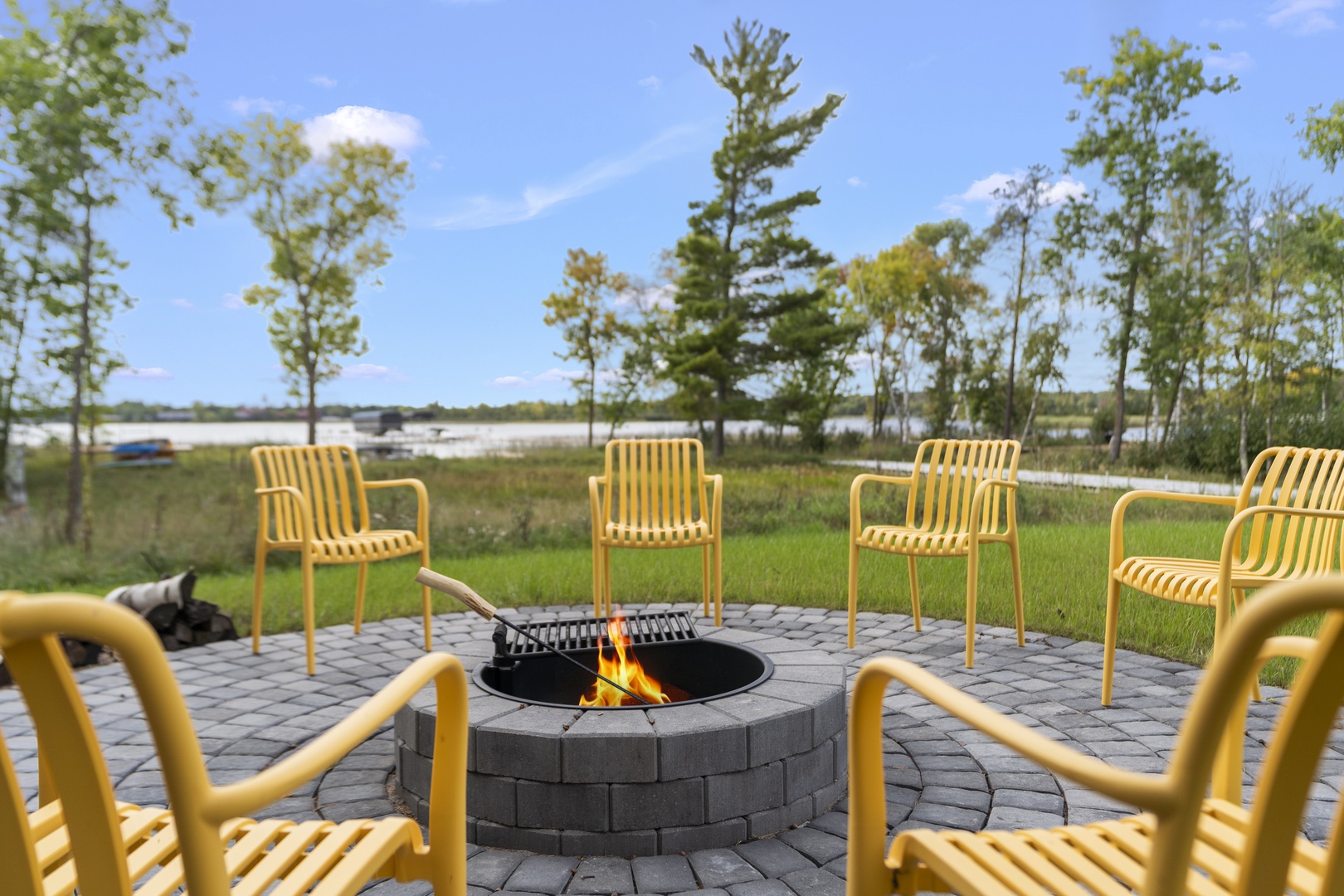 Fire pit near the house, circled by bright yellow chairs