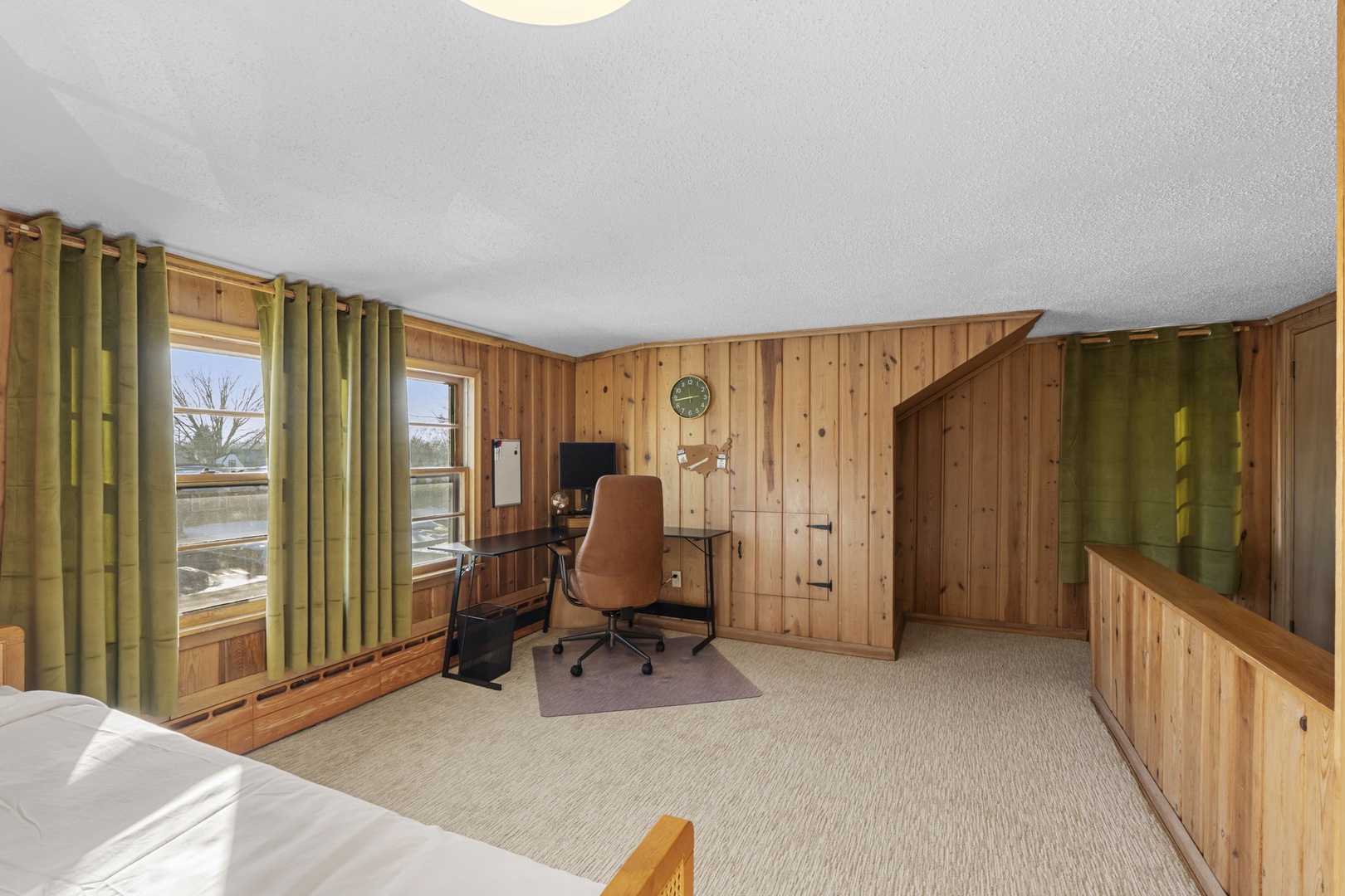 The multipurpose space on the second floor features a desk, monitor, and desk chair.
