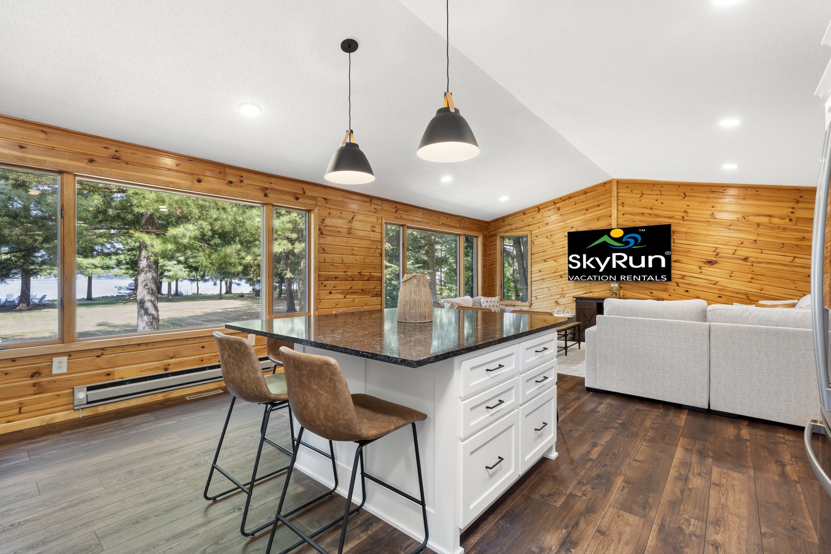 Sit back and take in the lake view from the kitchen island, with the open living room and its cozy sectional just beyond.