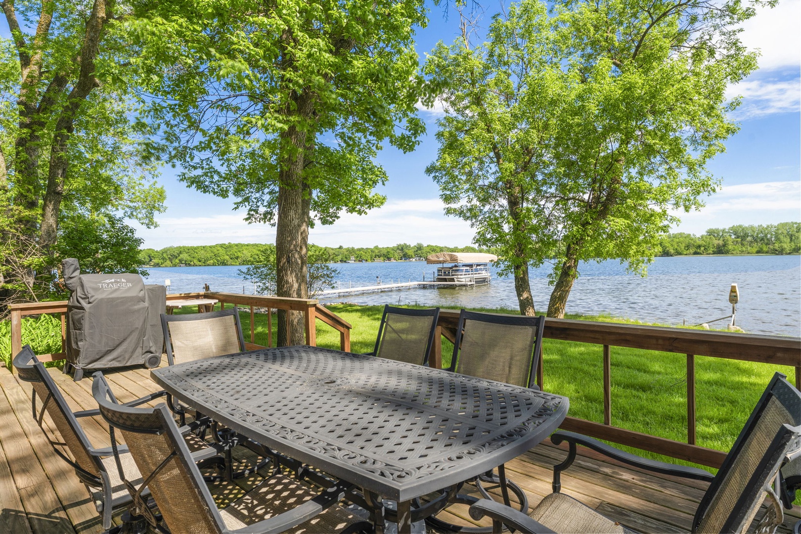 Picture yourself dining al fresco on this spacious deck, where shaded trees frame serene lake views and your private dock awaits for waterfront adventures.
