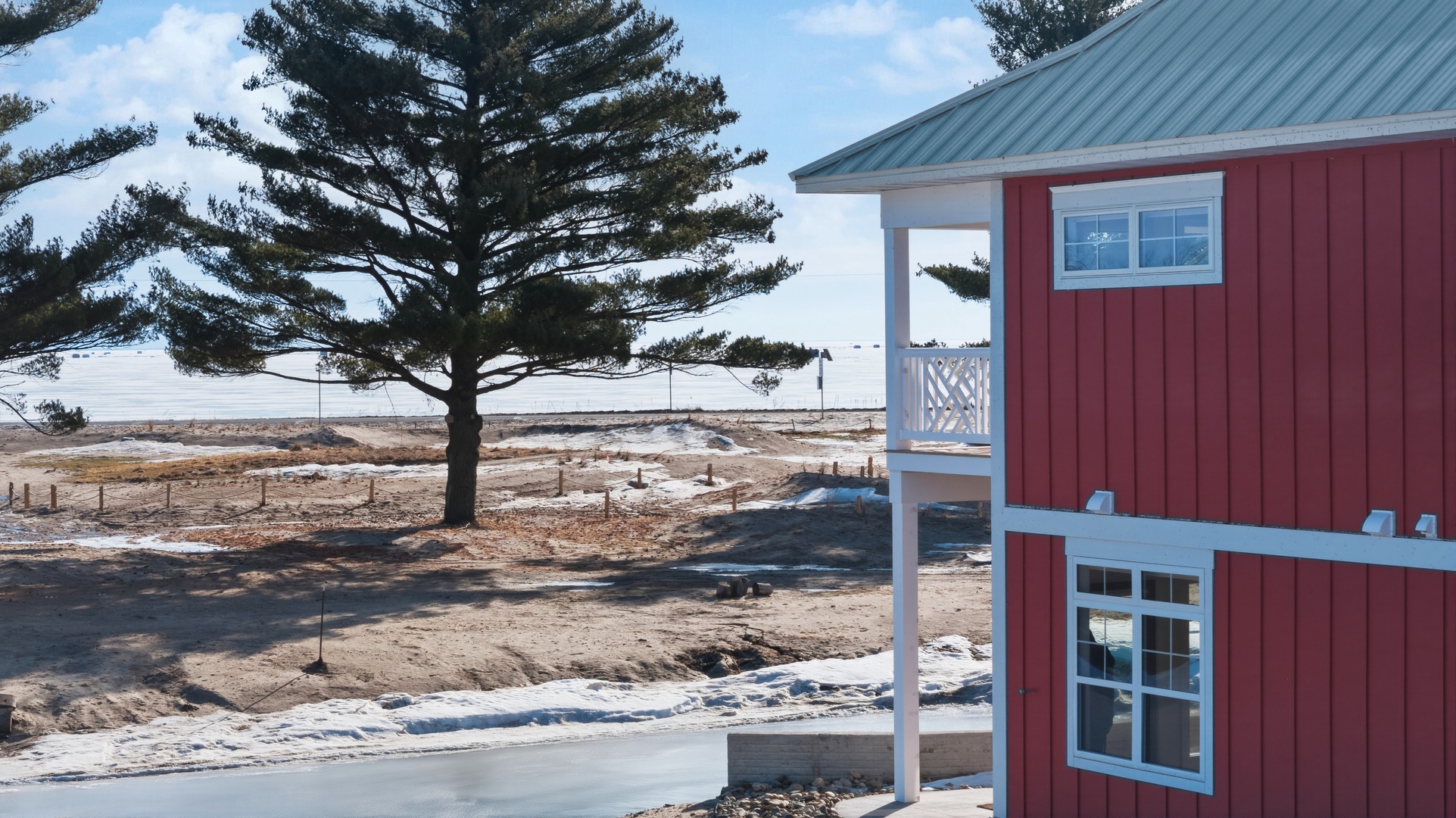 Red house with lake views and mature pine trees from above
