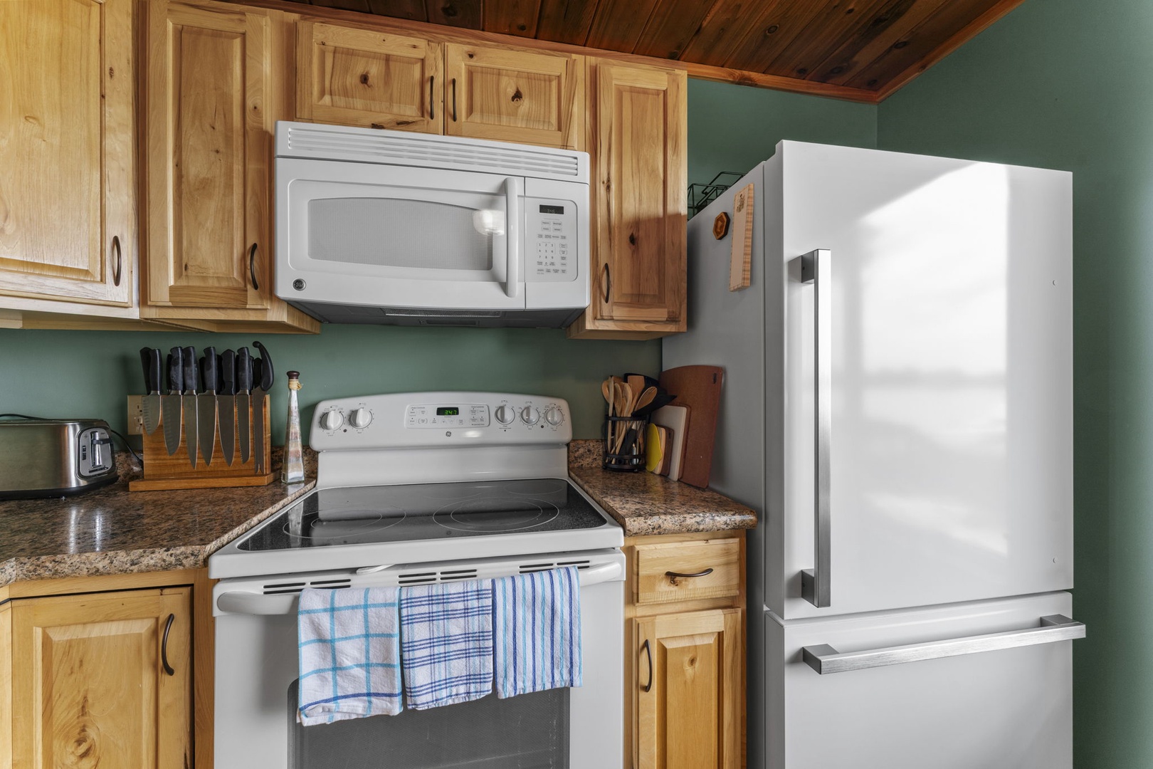 Your fully equipped kitchen features modern appliances, granite countertops, and warm wood cabinetry—everything you need to whip up a home-cooked meal or morning coffee during your stay.