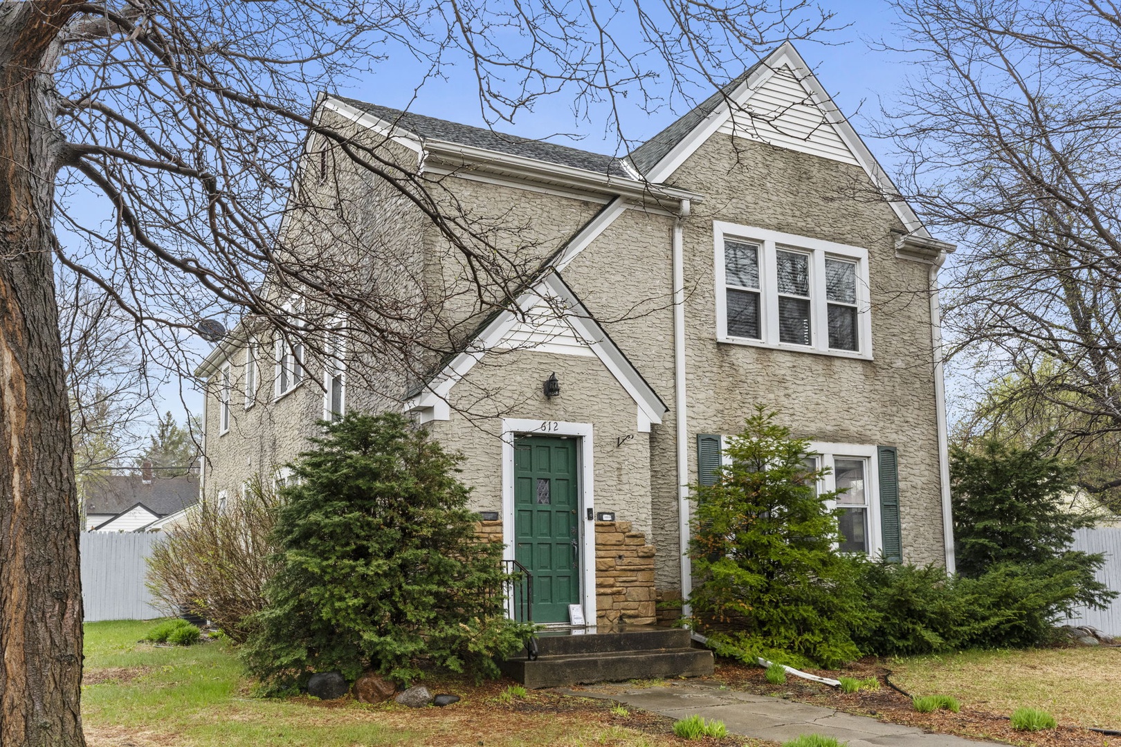 Charming brick home with classic architectural details and established landscaping, located in a peaceful neighborhood setting.