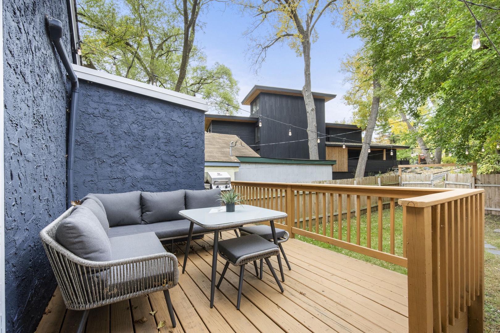 Step out to your private deck with comfortable seating and a table, perfect for morning coffee or evening relaxation amid tree-lined views and modern design.