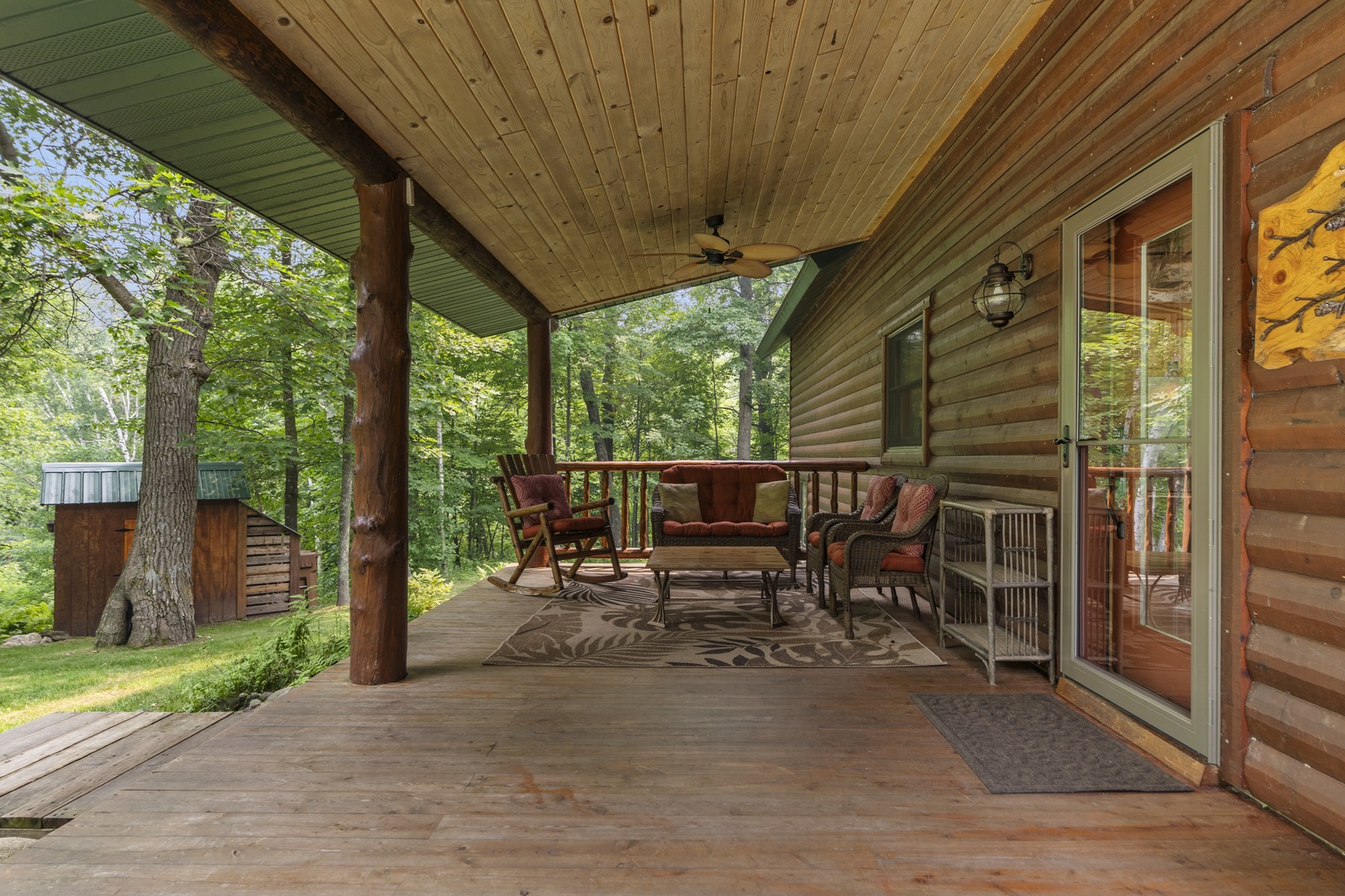 Settle into your private covered porch surrounded by towering trees, where comfortable seating invites you to unwind with morning coffee or evening conversations in the fresh forest air.