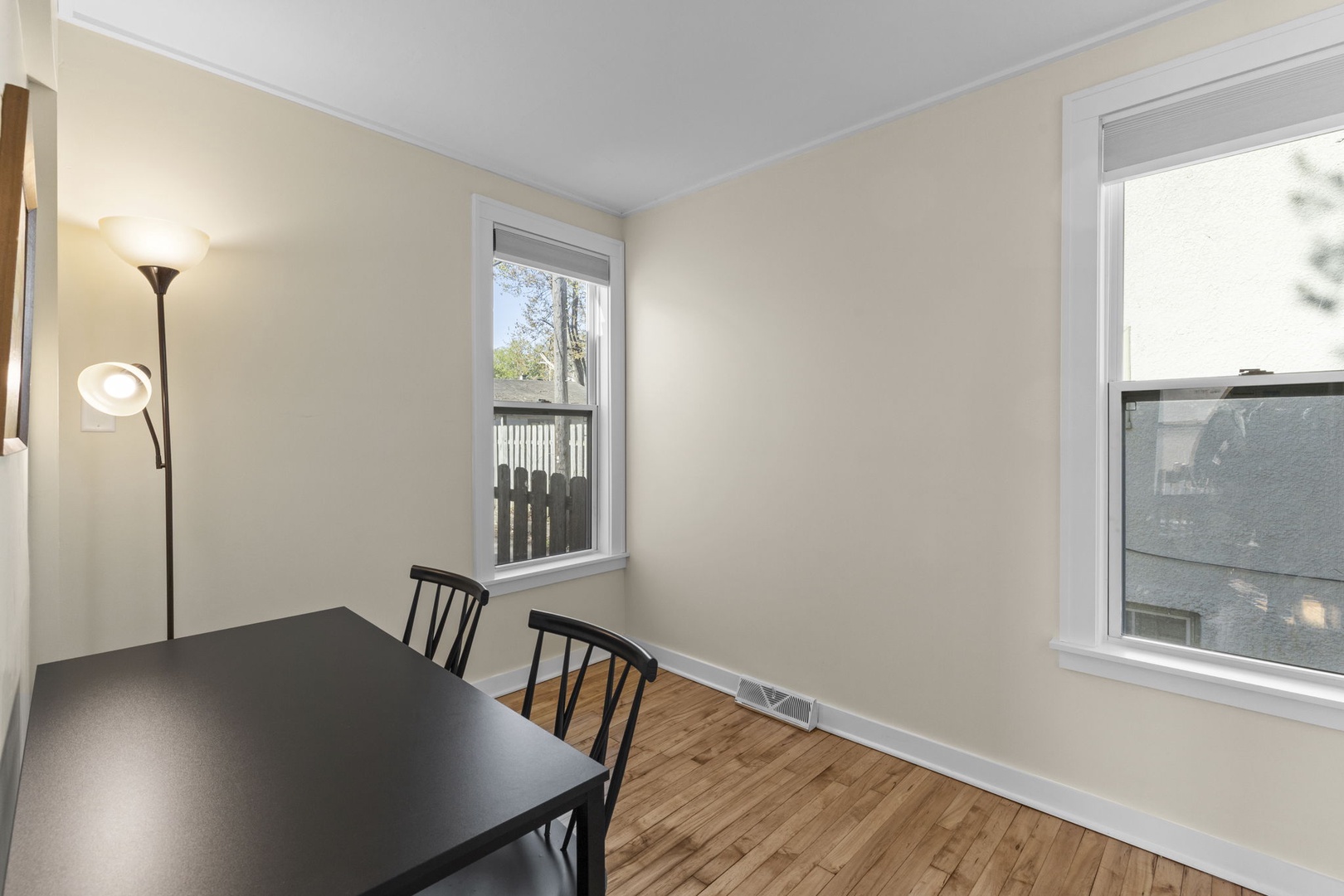 Dedicated workspace with a large desk, two chairs, and bright double windows — ideal for remote workers or as a flexible bonus room.