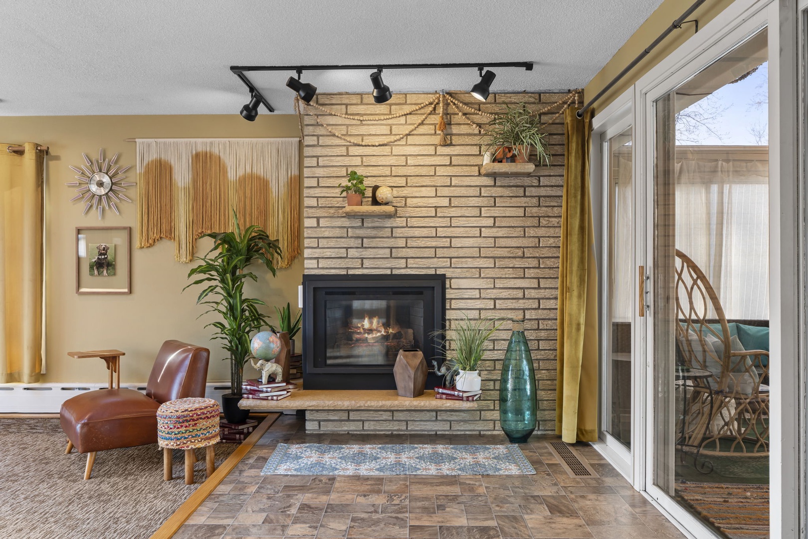 Unwind by the cozy fireplace in your stylish living room, where warm brick walls and plants create the perfect retreat.