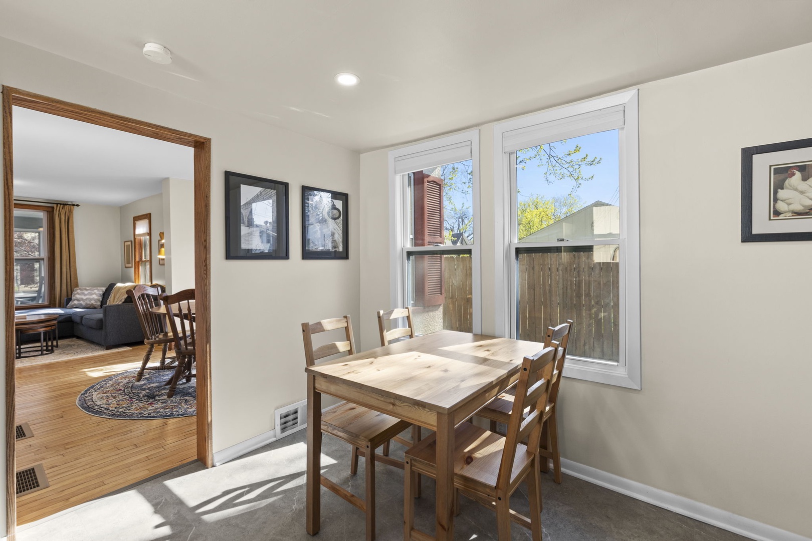 Sunny eat-in kitchen nook with a wood table for four, bright windows, and easy access to the main kitchen — perfect for a casual breakfast or working from home.