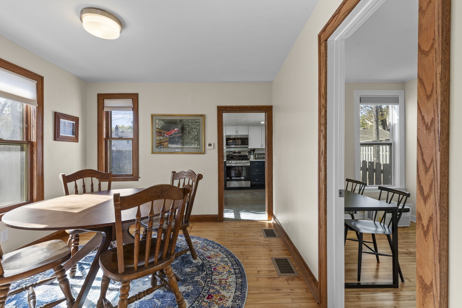 Dining area with views directly into the renovated kitchen and the bright sunroom beyond — a well-connected, light-filled space for every meal.