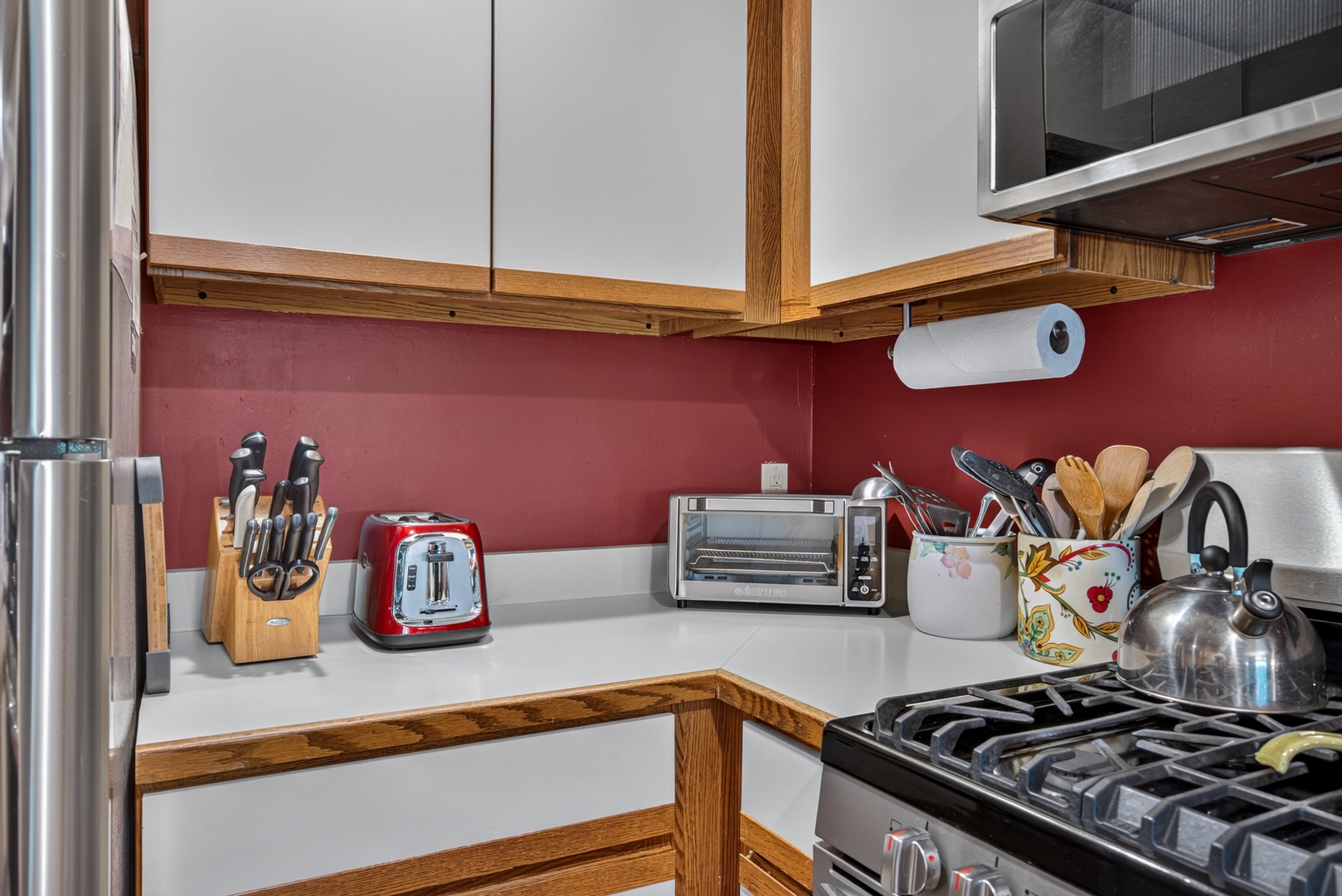 Your fully equipped kitchen awaits with everything you need to whip up delicious meals. Warm wood tones and a vibrant red backsplash create an inviting space to cook and gather.