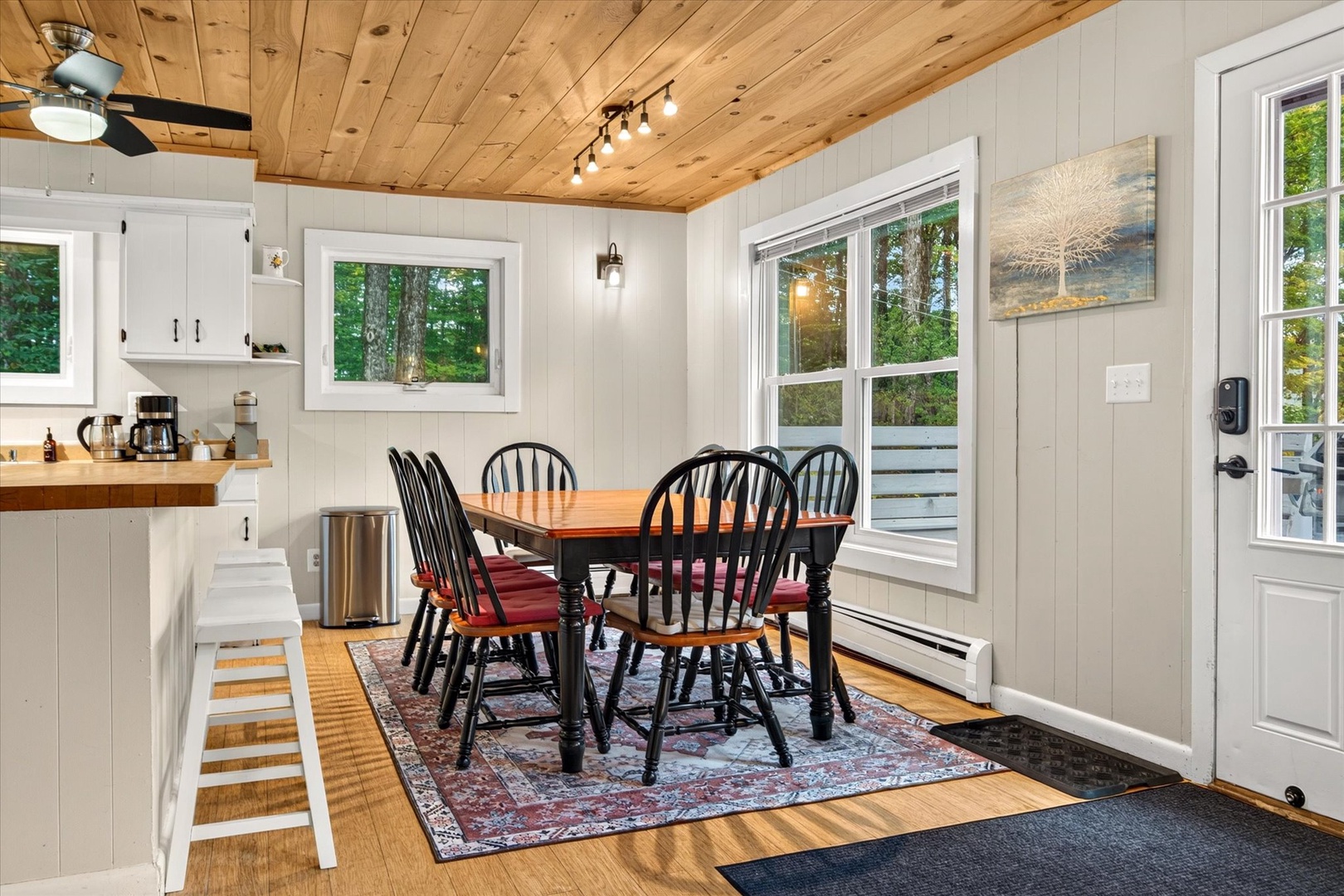 Step into your welcoming dining space, where a warm wooden ceiling and bright windows create a cozy retreat perfect for morning coffee or leisurely meals with loved ones.