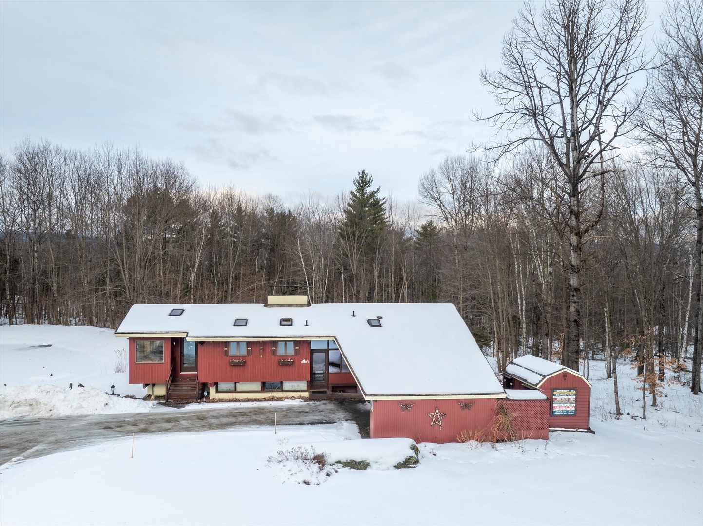 Inviting home tucked into a quiet winter landscape, surrounded by snow-dusted trees and tranquil mountain scenery.