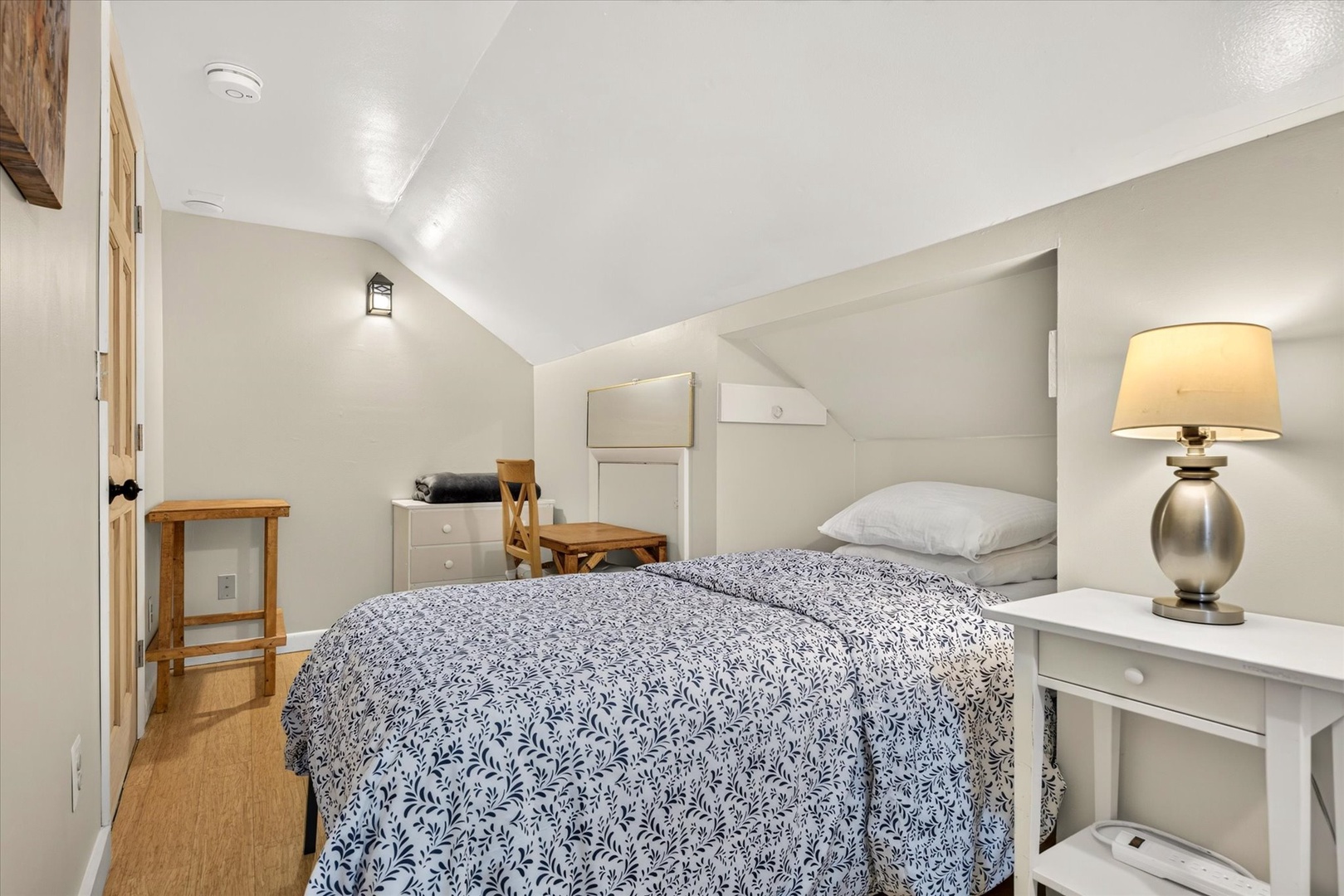 Slip under soft linens in your cozy upstairs retreat, where vaulted ceilings and warm lighting create a peaceful sanctuary for restful nights.