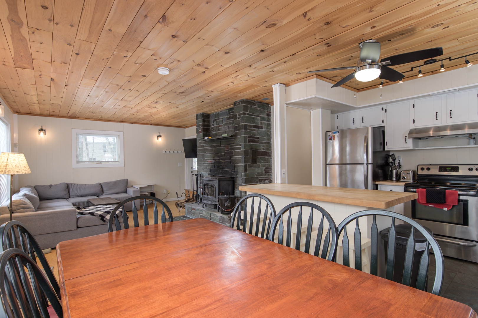 Gather around your spacious dining table while the stone fireplace crackles nearby, creating the perfect atmosphere for memorable meals together.