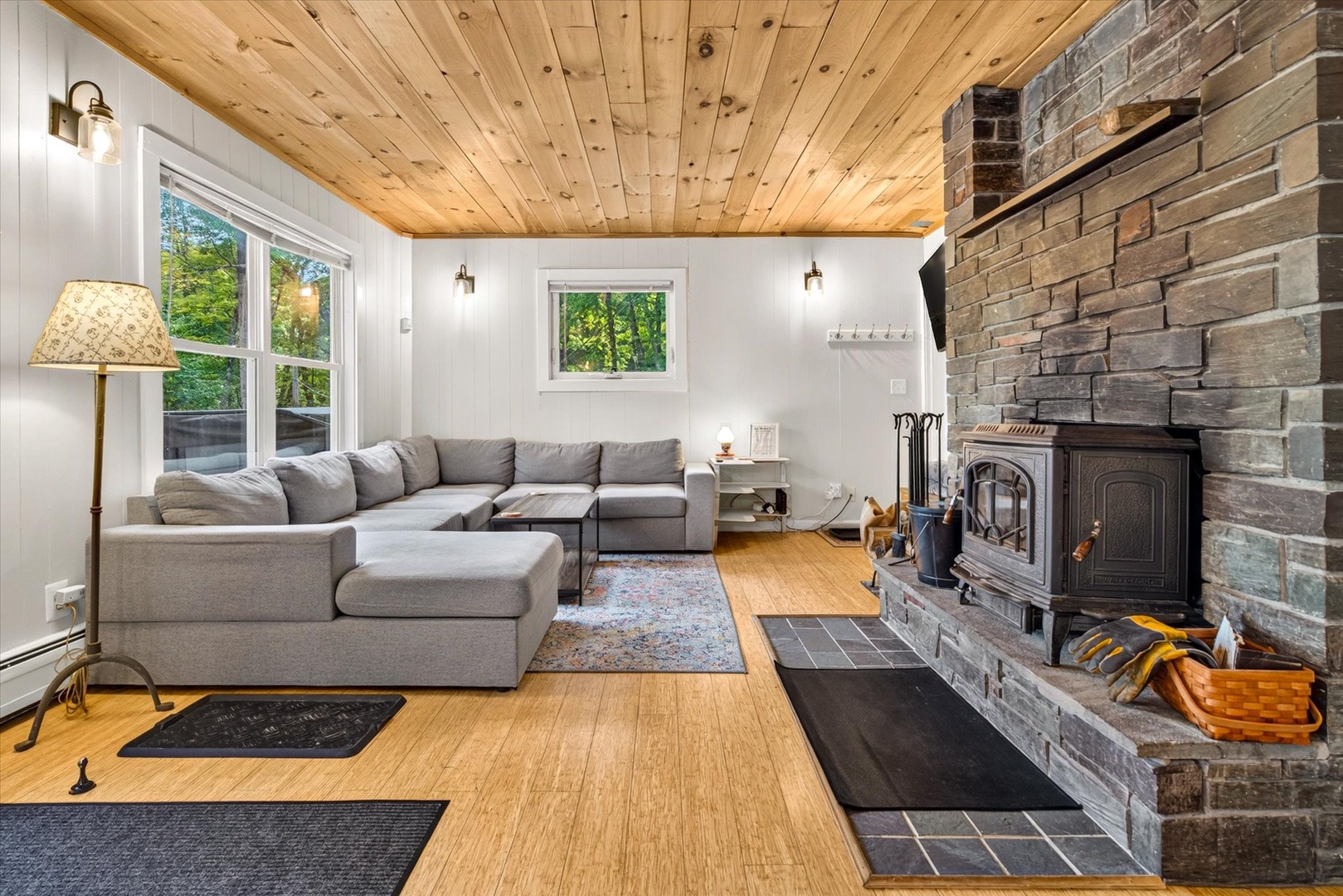 Settle into your cozy living room, where natural wood ceilings and a stunning stone fireplace create the perfect retreat after a day of exploring.