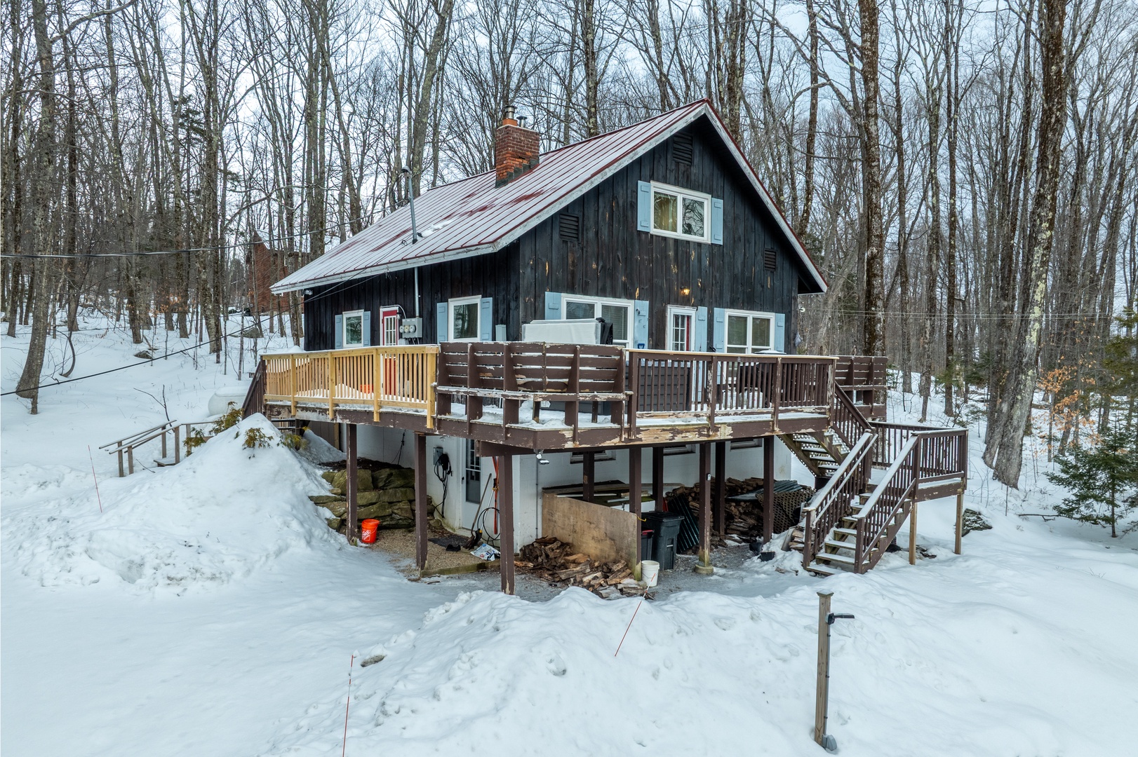 Mountain cabin featuring a spacious wraparound deck and private hot tub, surrounded by peaceful forest scenery for the perfect alpine adventure..
