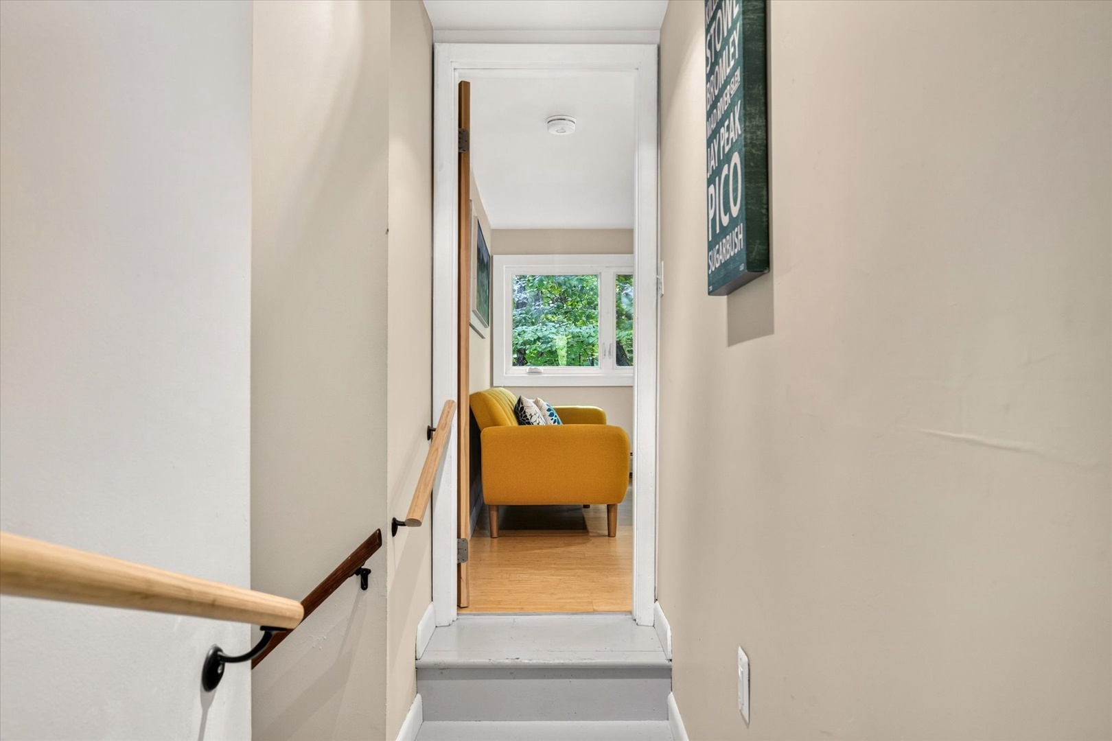 A bright hallway leads you to a cozy seating nook with lush garden views—your perfect spot to unwind and watch the world outside.