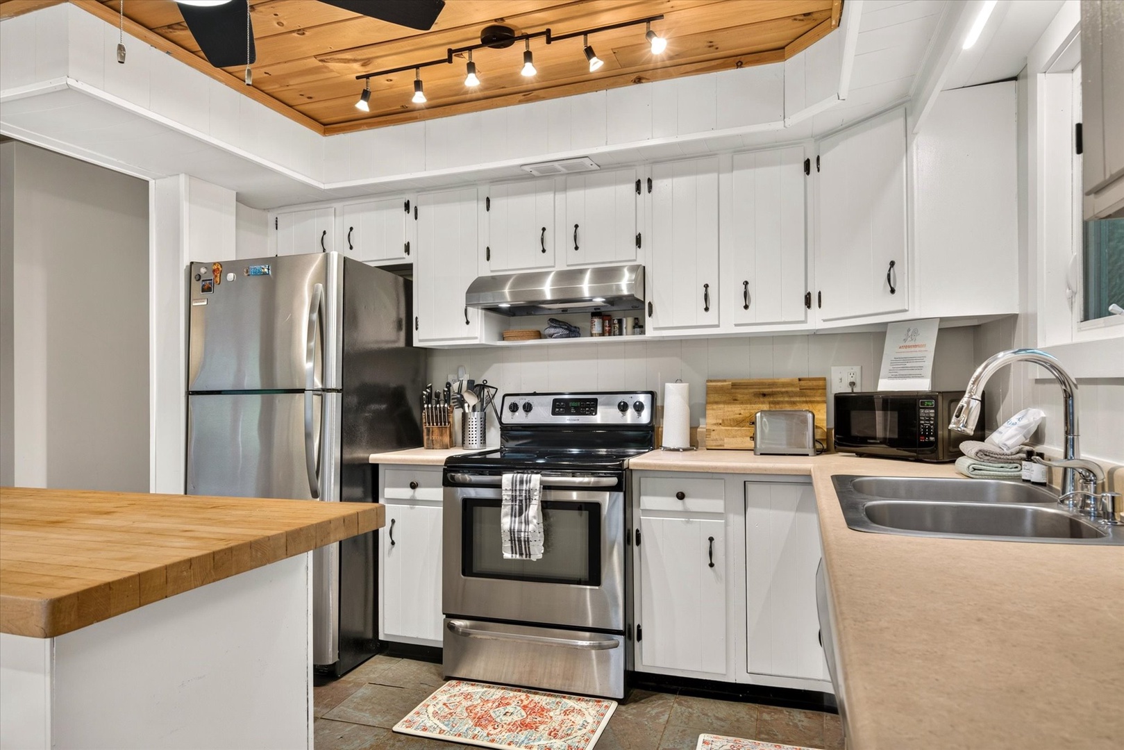 Cook up your favorite meals in this bright, fully equipped kitchen with stainless steel appliances, ample counter space, and warm wood accents overhead—everything you need for a comfortable stay.