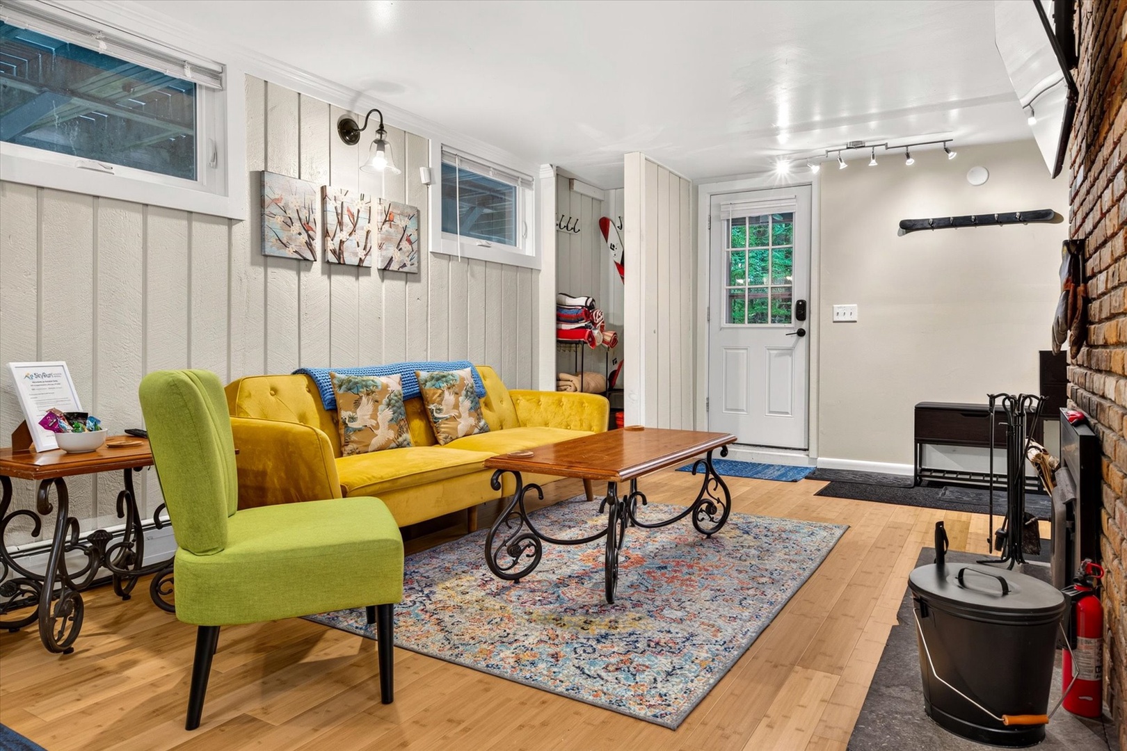 Step into your bright, welcoming living space with cheerful pops of yellow and chartreuse, rustic wood touches, and a cozy fireplace ready to warm your evenings.