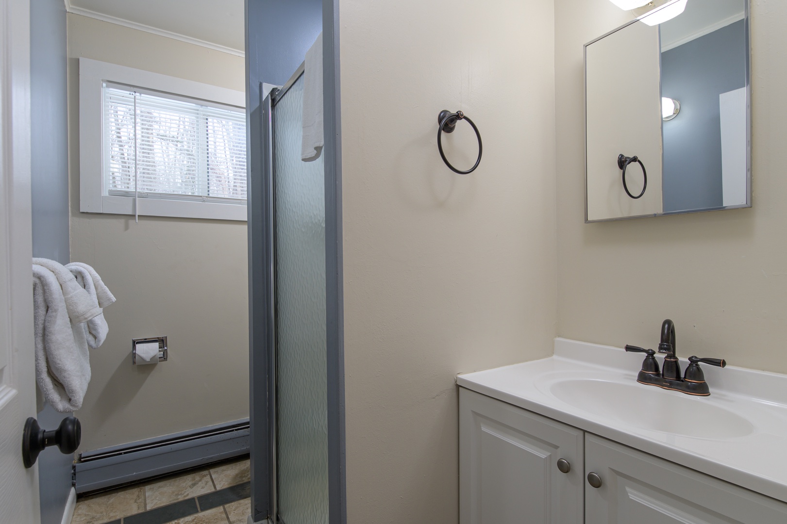 Your bright 2nd floor bathroom features a spacious vanity and refreshing shower, with fluffy towels ready for your comfort.