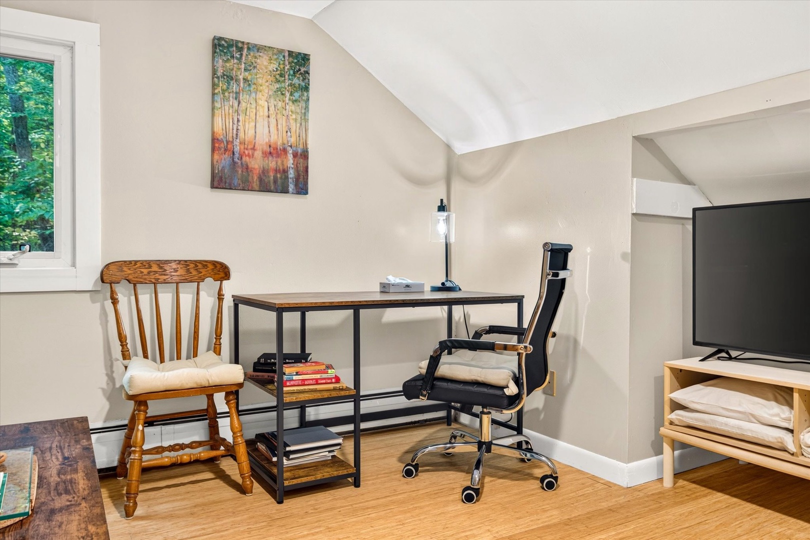 Your dedicated workspace awaits, bathed in natural light from the nearby window. Settle into the ergonomic chair and find your focus at this thoughtfully arranged desk, perfect for catching up on work or planning your next adventure.