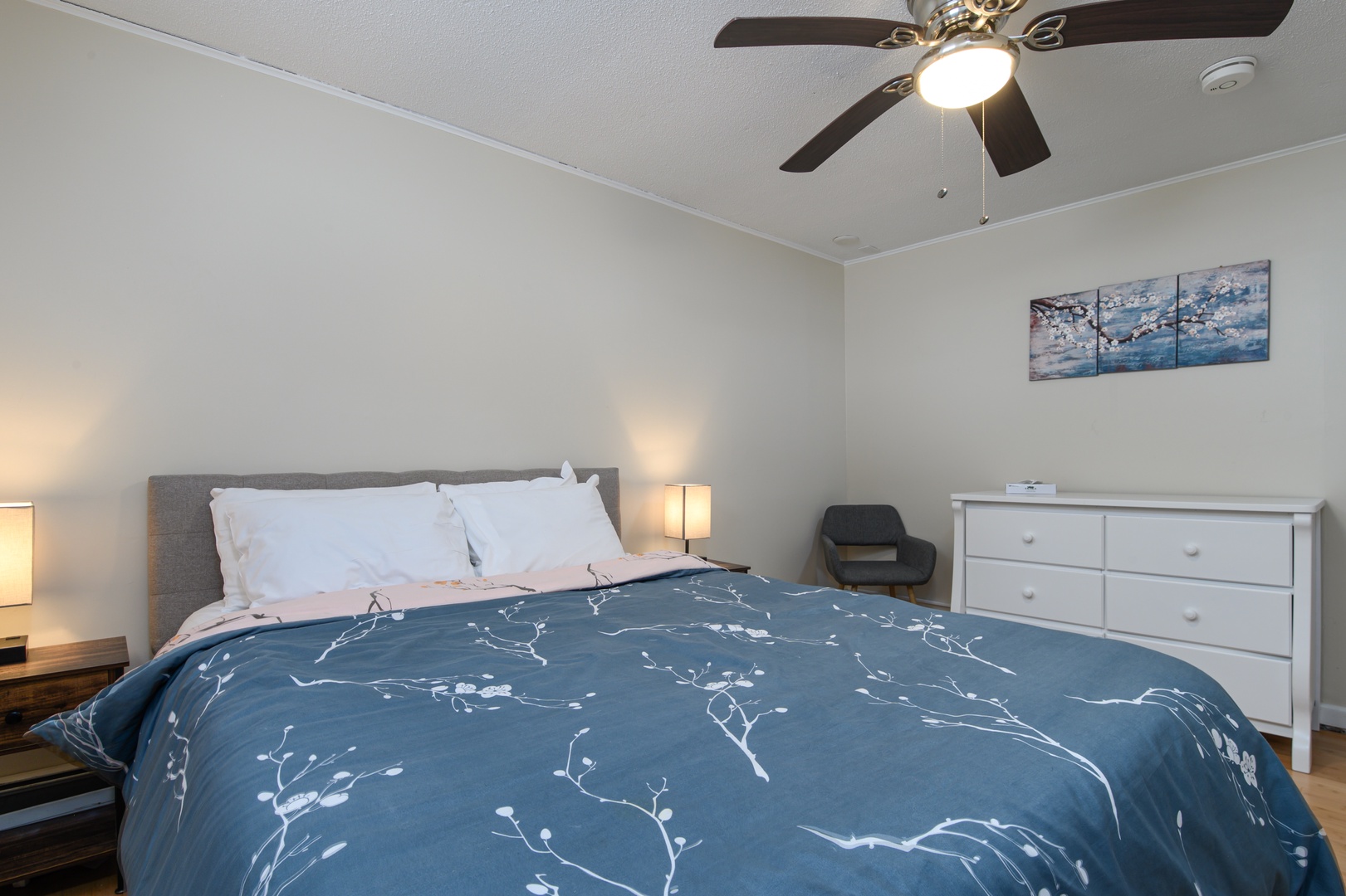 Rest easy in the second bedroom with a comfortable queen bed, soft lighting, and calming décor.