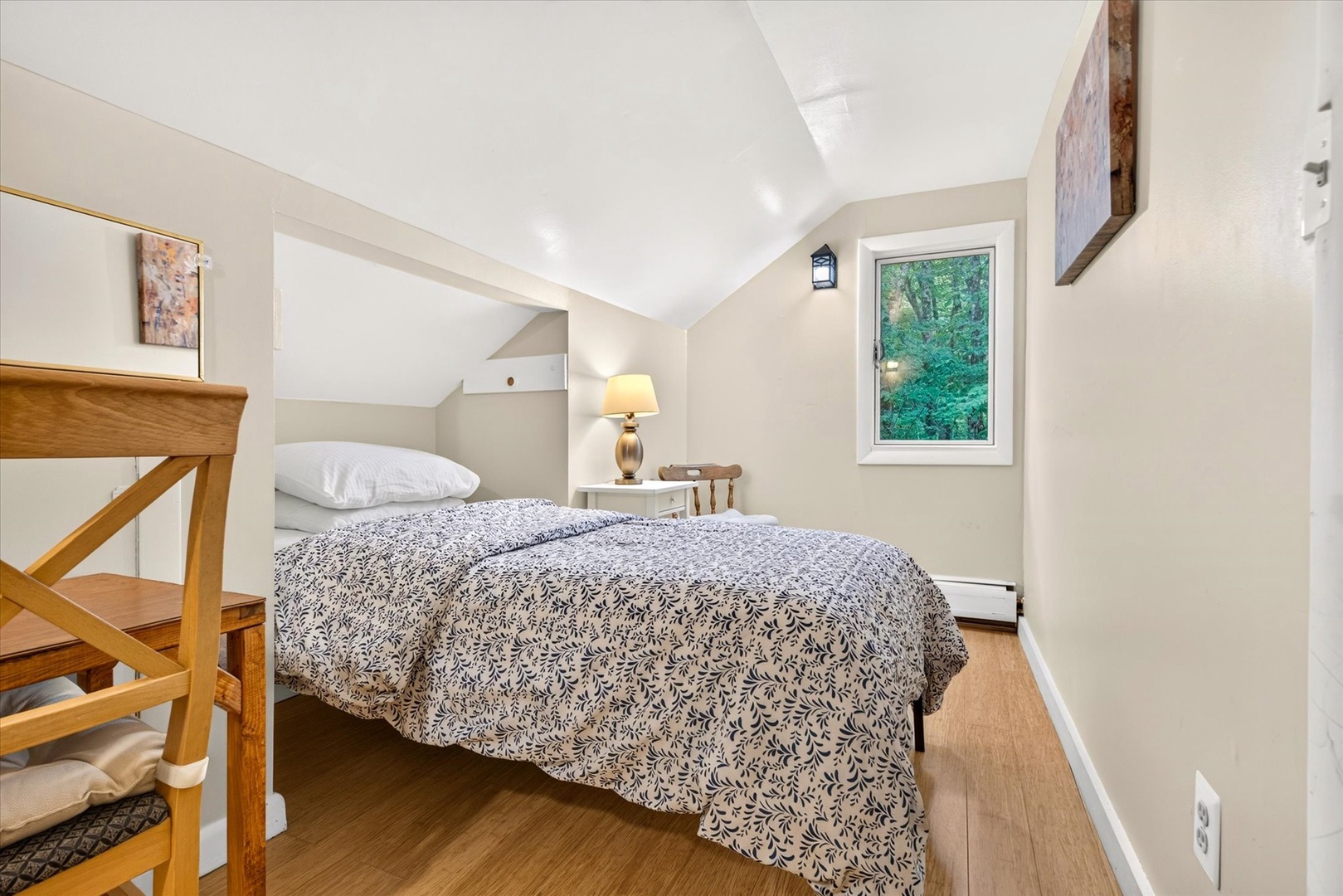 Your cozy bedroom features vaulted ceilings, warm wood floors, and a peaceful garden view—perfect for restful mornings after exploring the area.