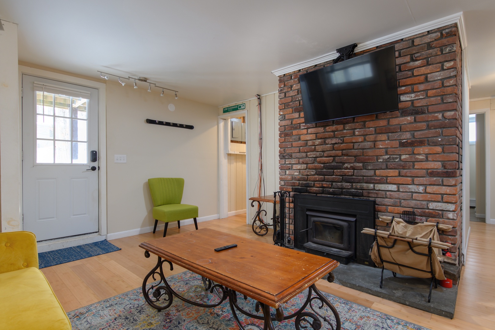 Cozy up in this charming living room featuring exposed brick fireplace, perfect for relaxing evenings with your favorite shows.