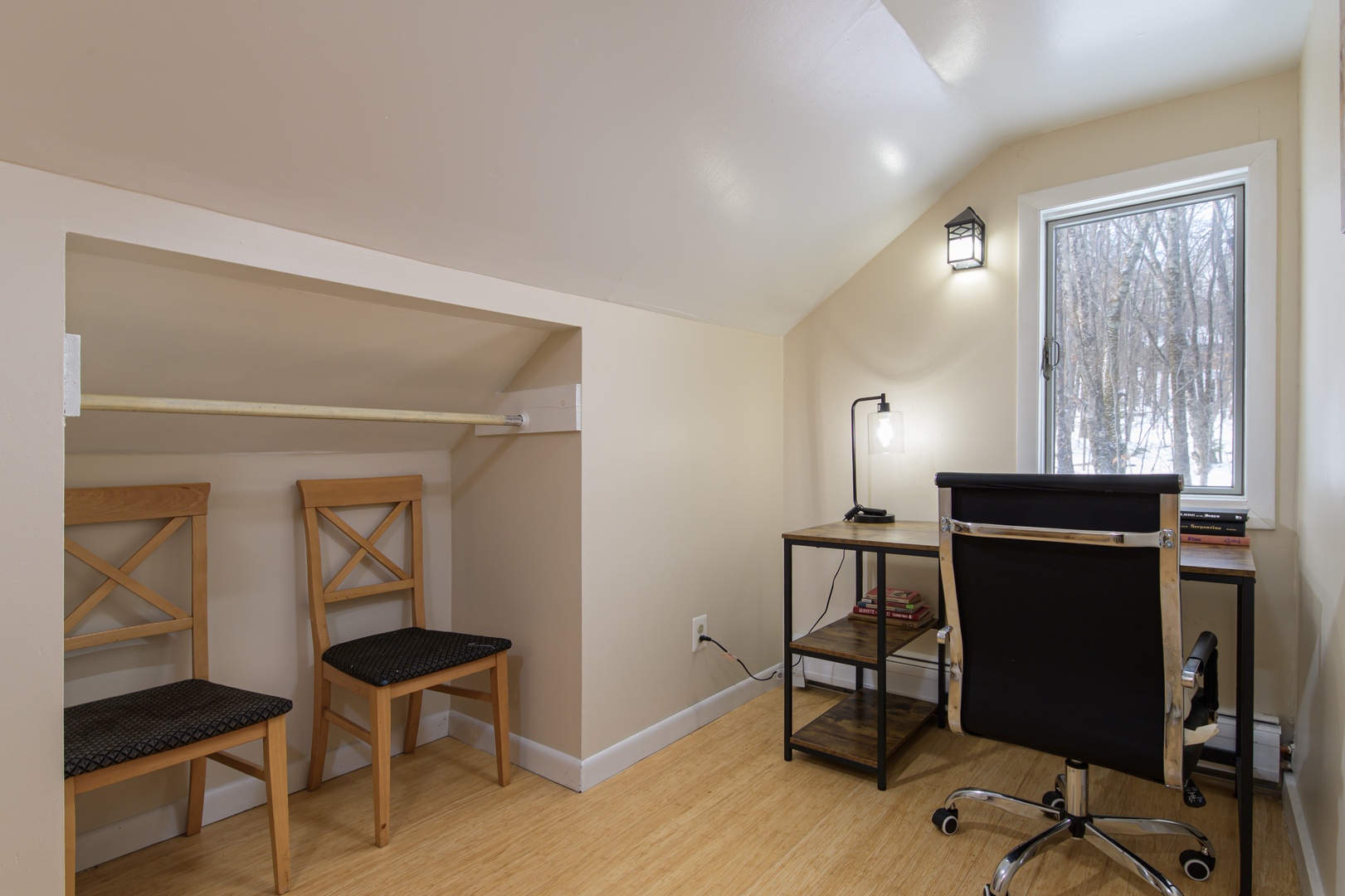 Your dedicated workspace awaits with a modern desk, ergonomic chair, and peaceful forest views to inspire productivity.