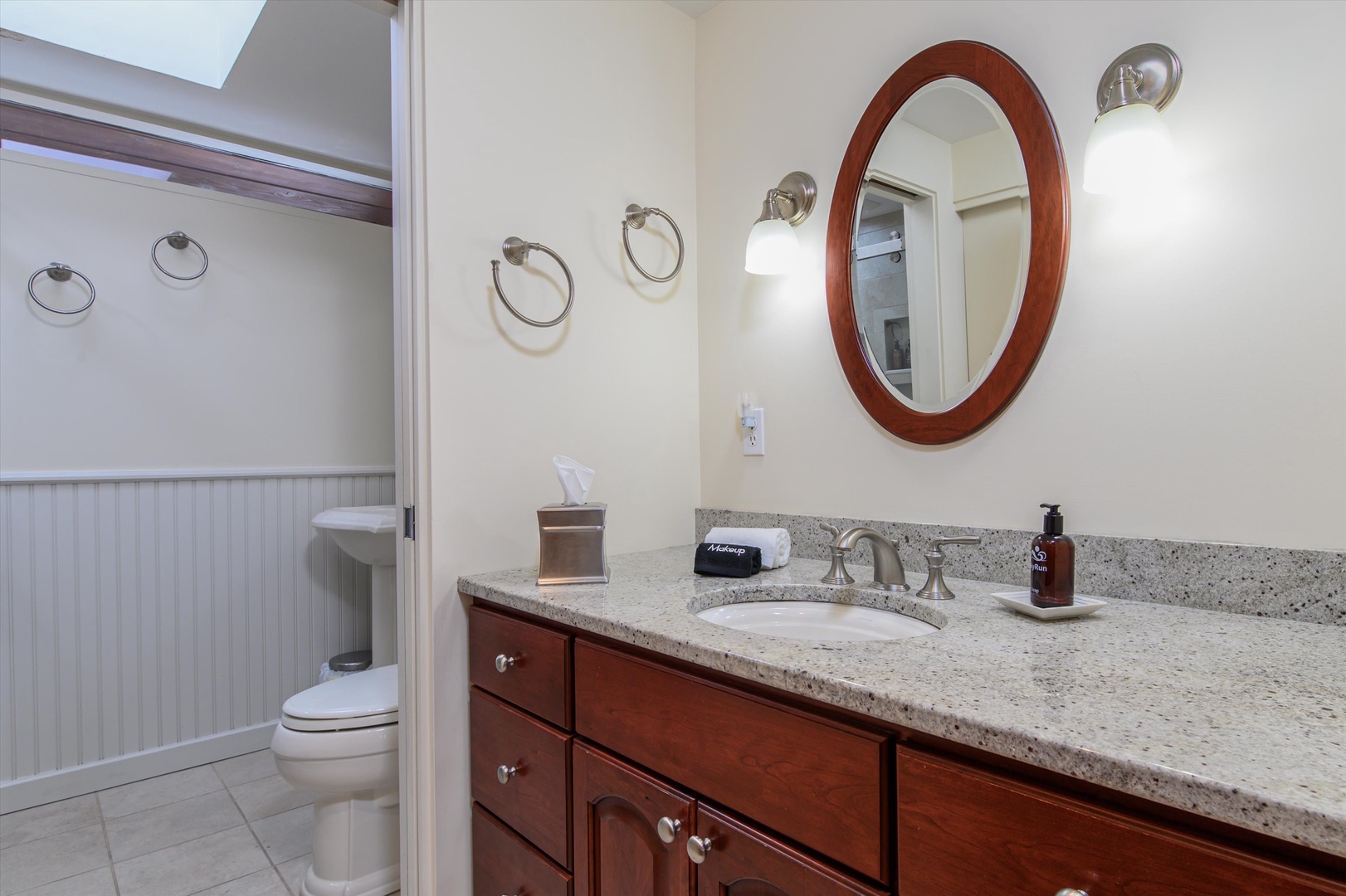 Freshen up in your elegant bathroom with granite countertops, warm wood vanity, and thoughtful amenities that make your stay feel like home.