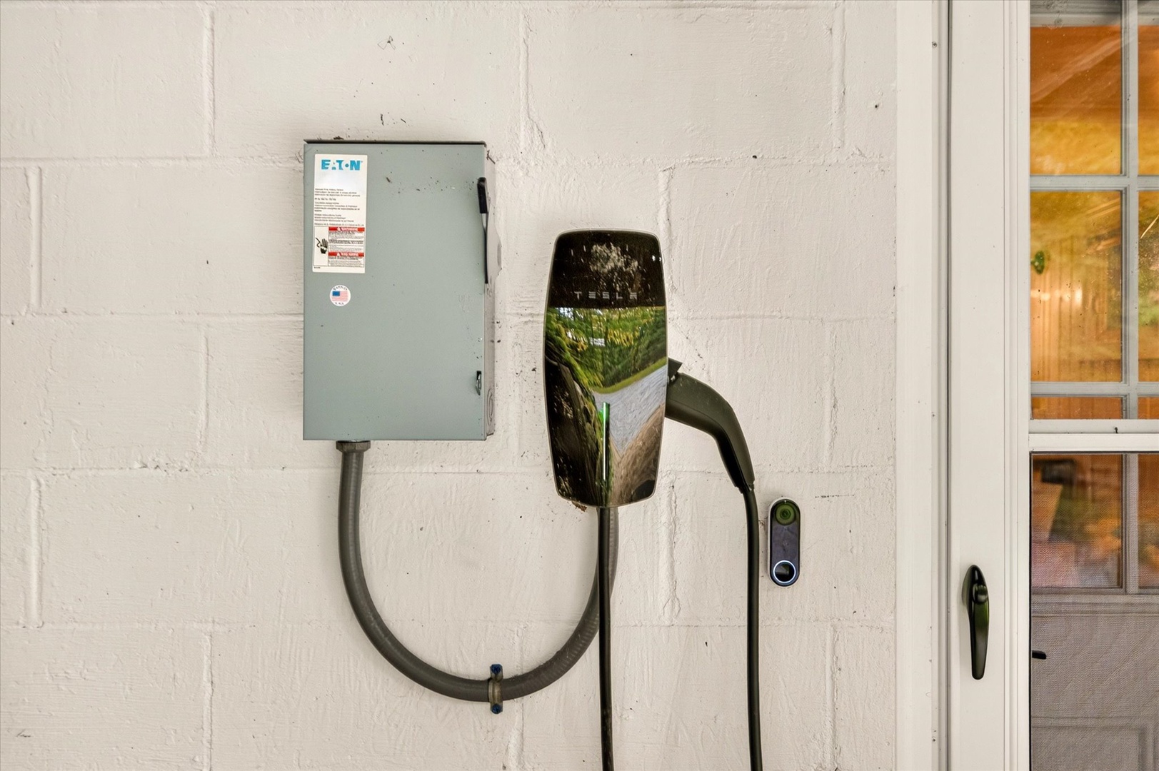 An electrical panel and charging station on the exterior wall, providing convenient EV charging access at the property.
