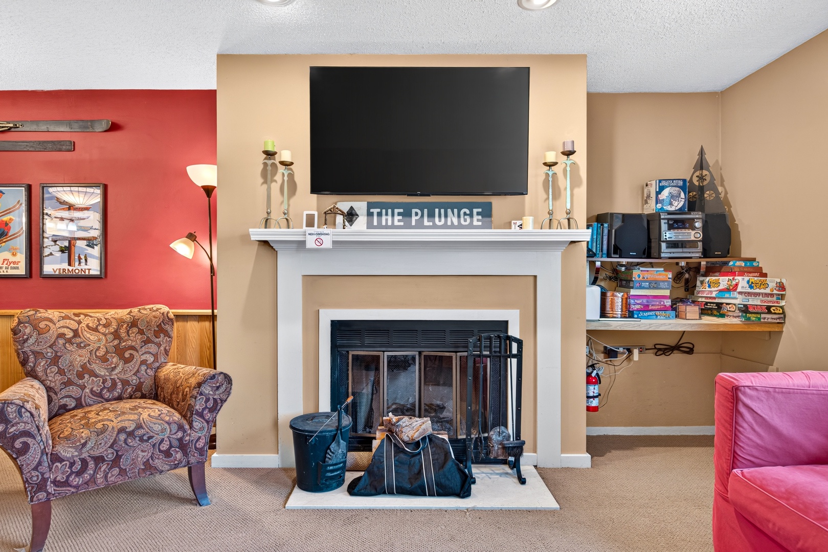 Cozy up by the fireplace in this inviting common area, complete with plush seating, a large TV, and shelves stocked with games for your entertainment.