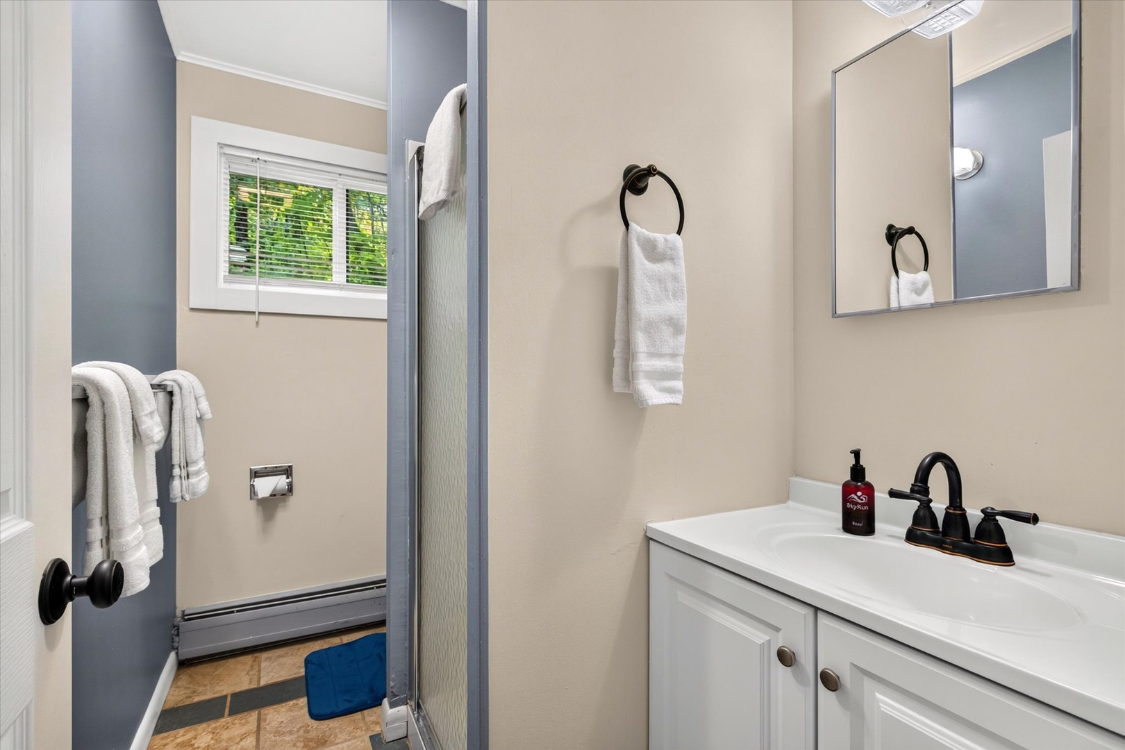 Your private bathroom offers crisp white cabinetry, fresh towels, and natural light—a bright, clean retreat where you can refresh after a day of exploring.