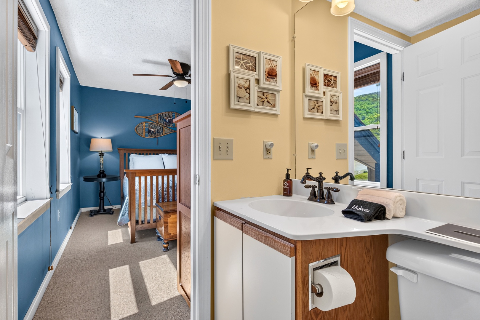 Refresh in this bright bathroom that connects to your cozy bedroom space, featuring nautical coastal accents and scenic mountain views through the window.