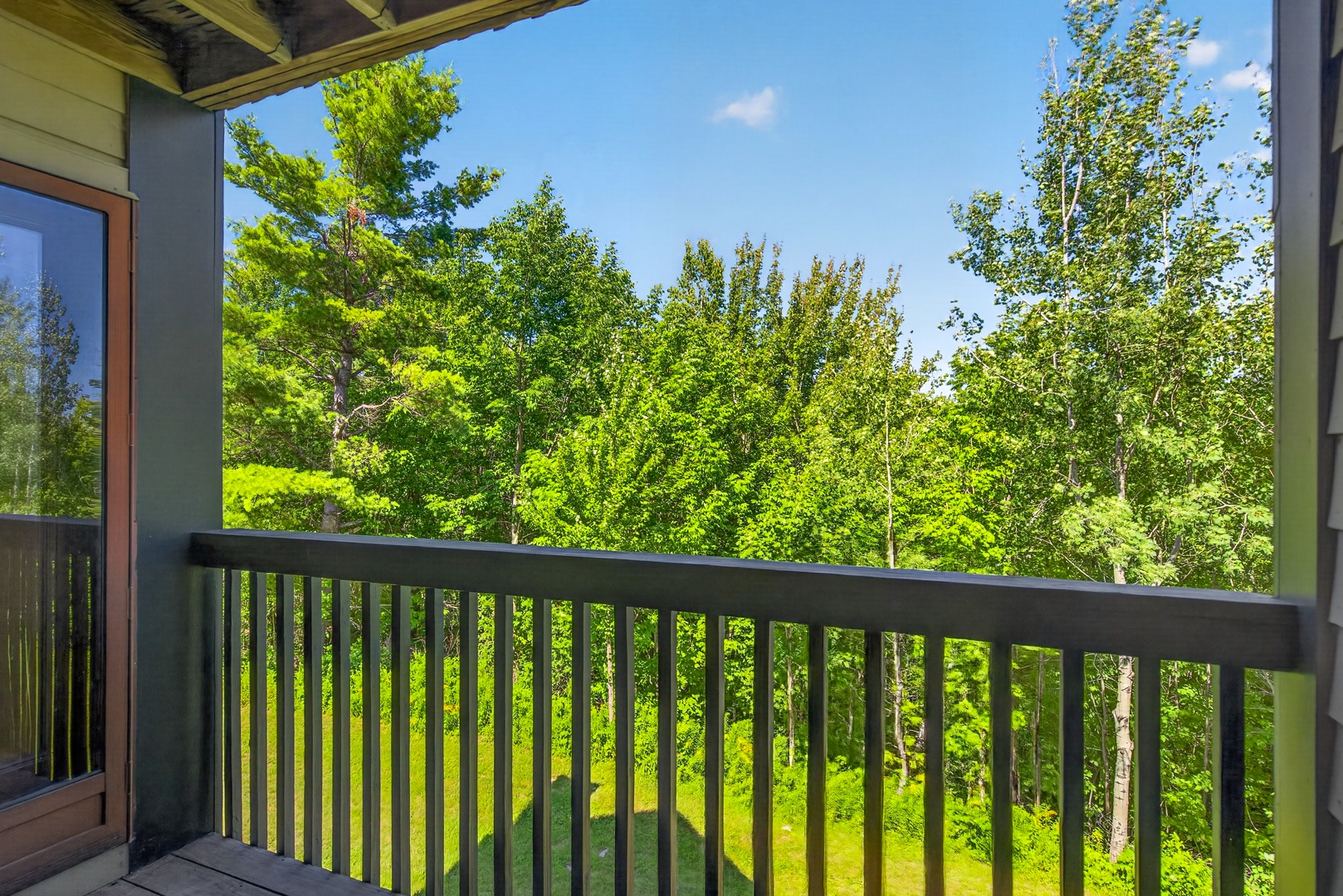 Step onto your private balcony and breathe in the fresh air as lush green trees surround you, offering a peaceful, natural retreat right outside your door.